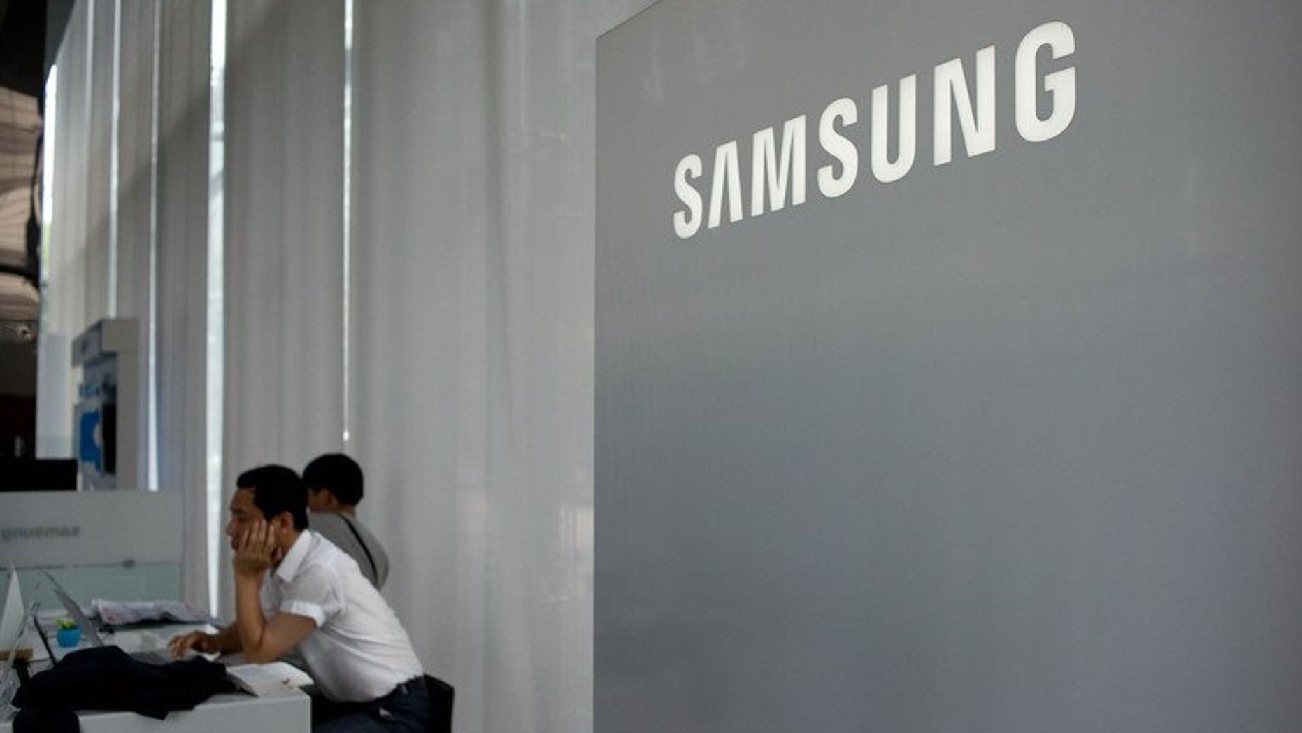 A Samsung logo is displayed at a showroom in Seoul on July 5, 2013. South Korea's Samsung Electronics will unveil its new Galaxy Gear "smartwatch" early next month, ahead of Apple's iWatch, Bloomberg news and a fan site said Saturday.