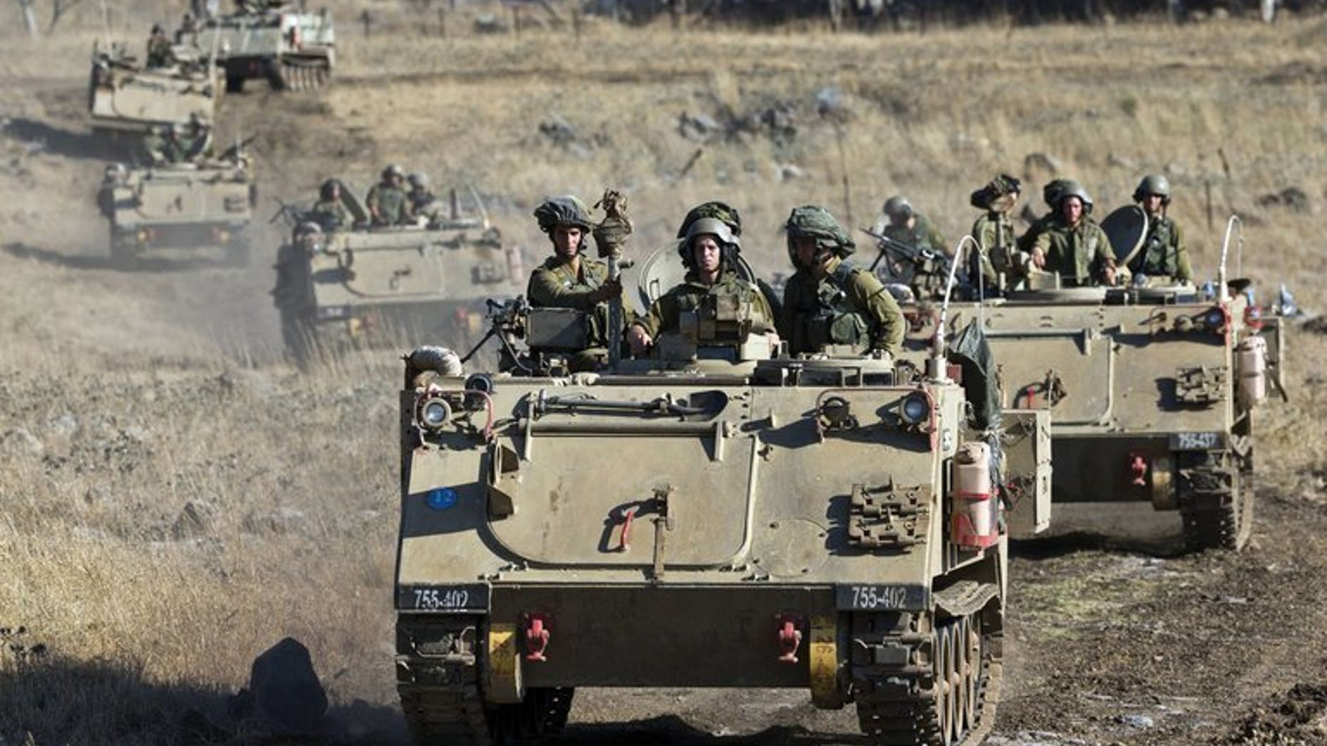 Israeli army Armored Personnel Carriers maneuver during a military exercise near the northern border with Syria on June 25, 2013. The Israeli army fired into Syria after shells from the neighbouring country hit the Israeli-occupied sector of the Golan Heights on Saturday, a military spokesman said.