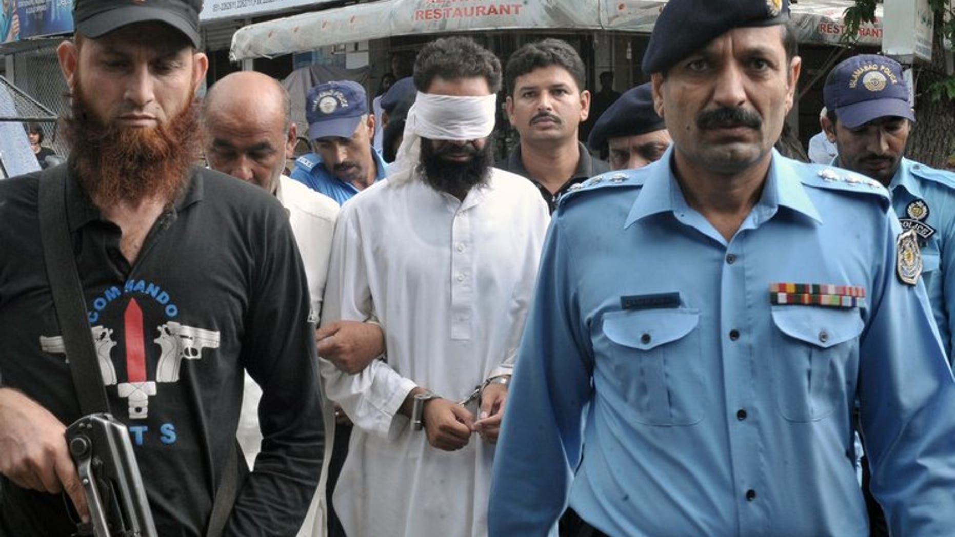 Pakistani policemen escort Islamic cleric Hafiz Mohammed Khalid Chishti (C) upon his arrival at a court in Islamabad on September 2, 2012. A Pakistan court on Saturday acquitted a Khalid Chishti, who accused a Christian girl of blasphemy before he himself was arrested on similar charges, a lawyer said.