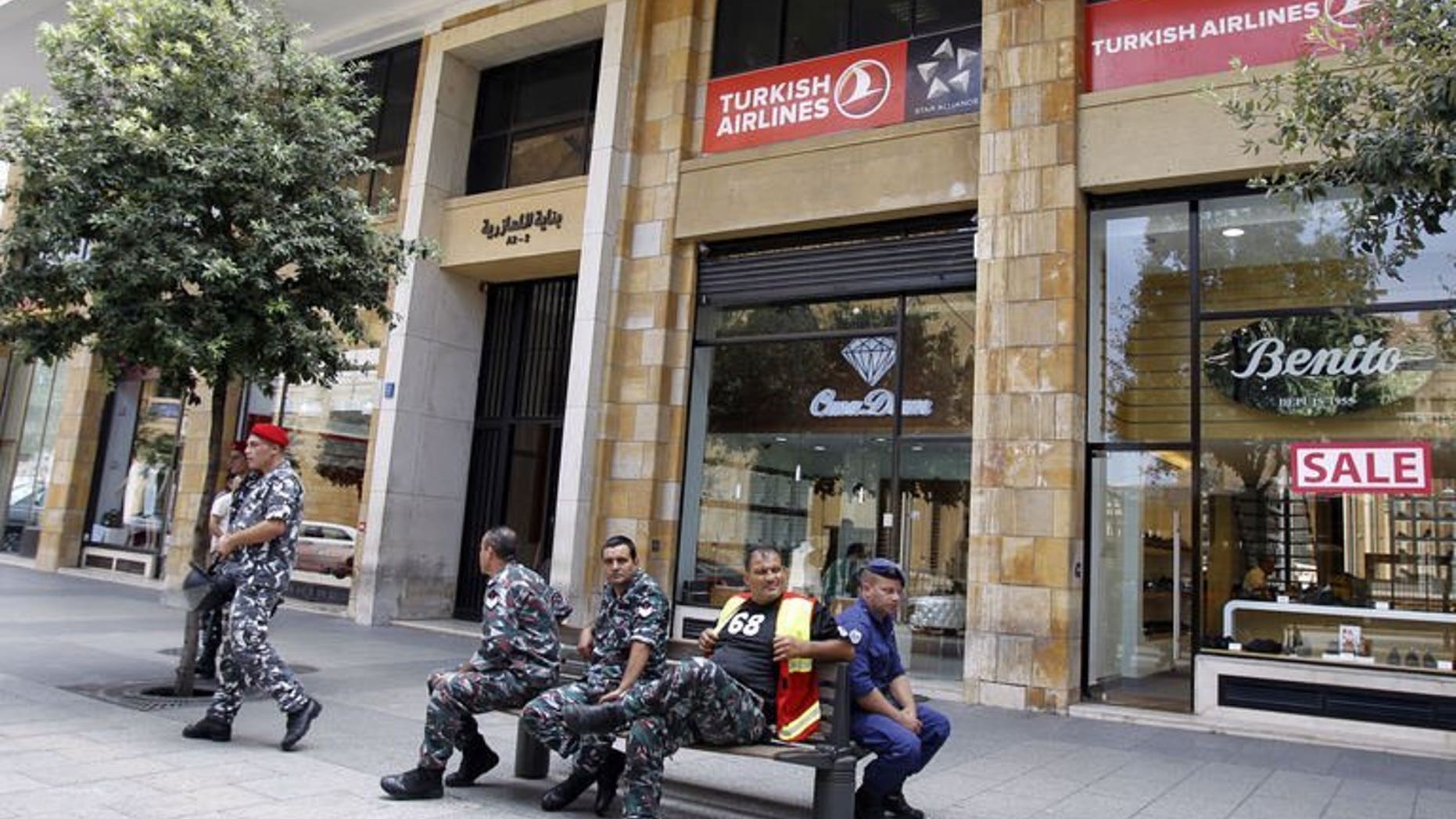 Members of the Internal security forces sit outside the Turkish Airlines offices in downtown Beirut on August 12, 2013. Lebanese authorities have arrested three suspects and charged them in connection with the abduction of two Turkish Airlines pilots, a judicial source told AFP on Saturday.