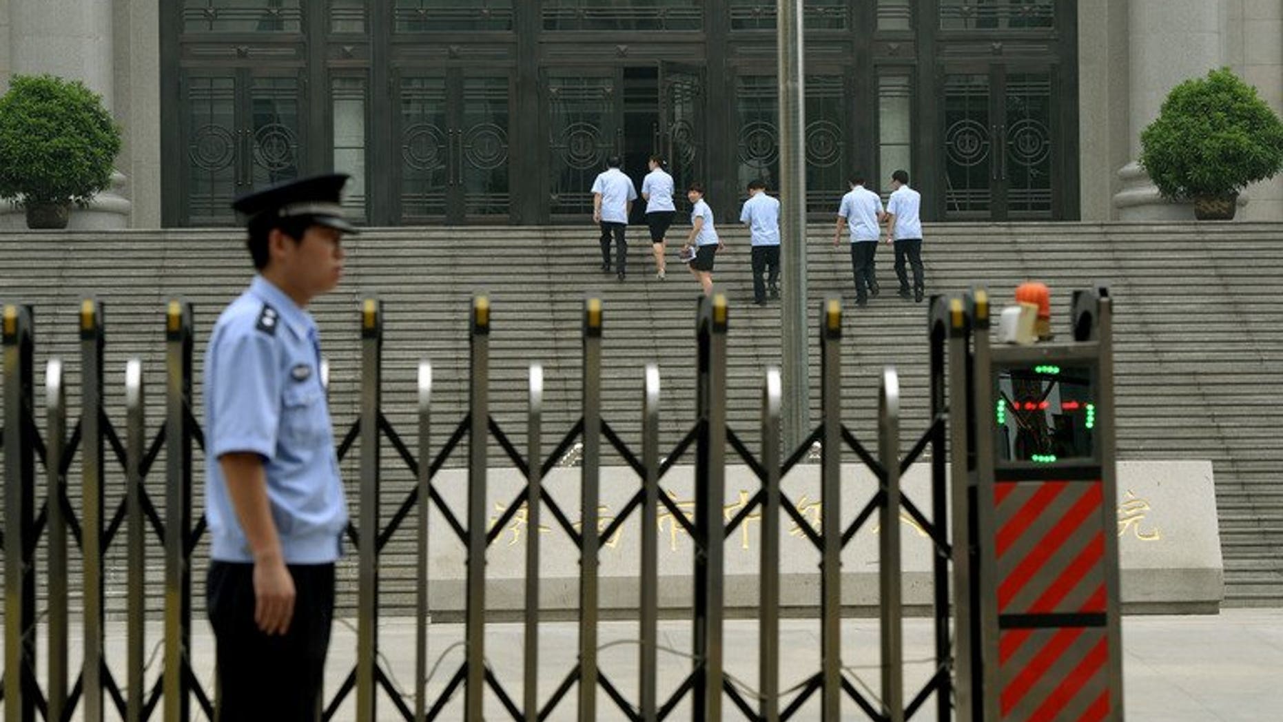 Police stand guard outside the Intermediate People's Court where Chinese politician Bo Xilai was indicted and his case expected to be heard in Jinan, Shandong Province on July 25, 2013. China's former top economic policymaker Liu Tienan has been placed under judicial investigation for suspected bribe taking, state media reported on Sunday.