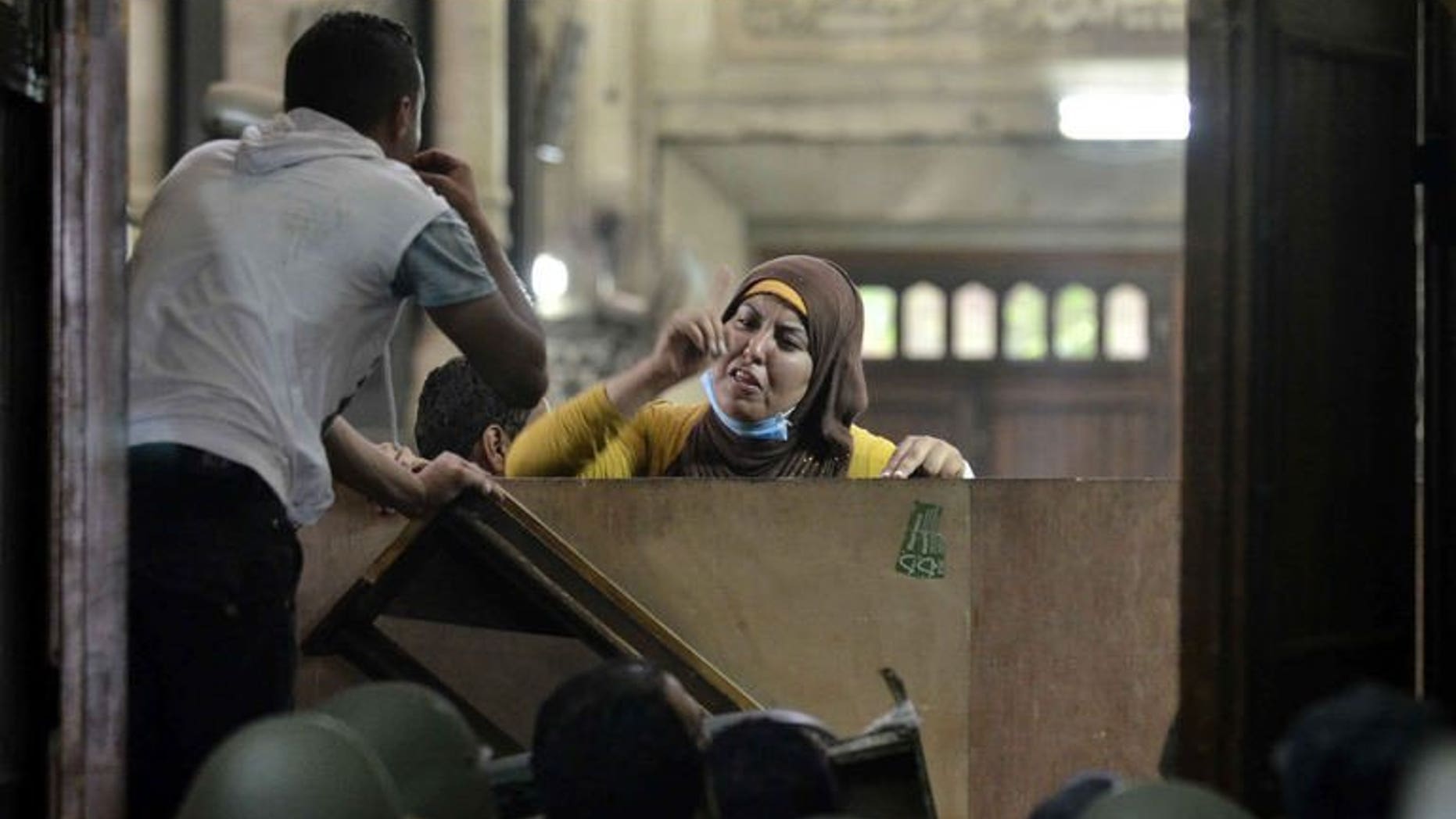 An Egyptian woman talks to policemen from the inside of Cairo's Al-Fath mosque where Islamist supporters of ousted president Mohamed Morsi held up on August 17, 2013. Qatar's foreign minister said Monday his country had never given aid to Egypt's Muslim Brotherhood and that all assistance went to Egypt as a whole.