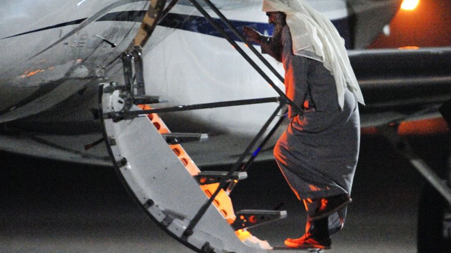 Radical Islamist cleric Abu Qatada boarding a privately chartered jet at the RAF Northolt base in west London on July 7, 2013, as he gets deported to Jordan. The family of the radical cleric, who faces terror charges in Jordan following his deportation from Britain, has arrived in the Arab kingdom, his brother said on Sunday.