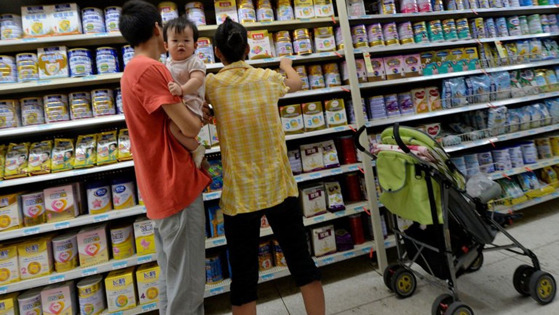 A Chinese family buys baby milk powder at a store in Beijing on August 7, 2013. The latest scare comes after an ingredient used in some baby formula contained a potentially deadly bug.