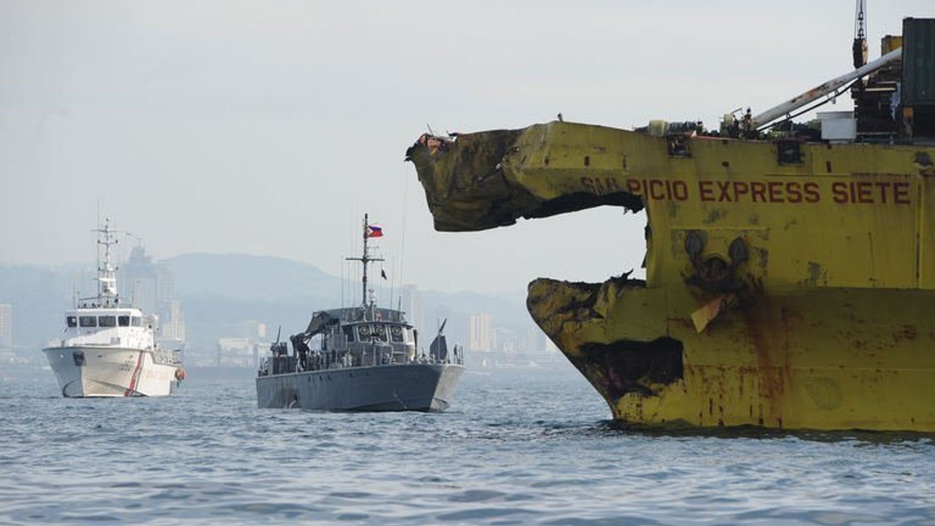A Philippine Coast Guard ship (L) and navy patrol boat (C) anchored next to a damaged cargo ship on August 17, 2013 after it collided with the ferry St. Thomas Aquinas near the central city of Cebu. The confirmed death toll from the ferry disaster rose to 64 on Tuesday as more bodies were found, some of them inside the sunken ship itself.