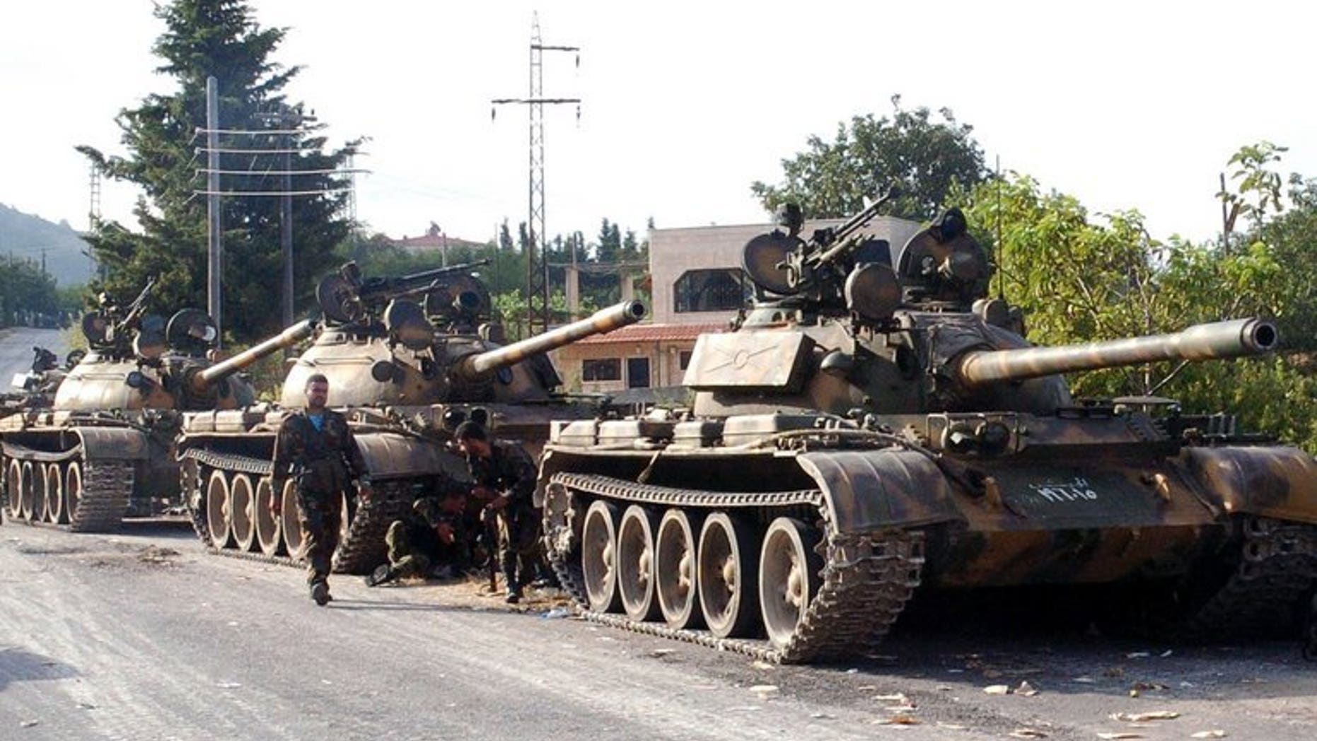 A picture released by the Syrian Arab News Agency (SANA) on August 8, 2013 shows Syrian army tanks parked on the side of a road during an alleged pursuit of opposition fighters in the Latakia province, western Syria. The Syrian army has recaptured all rebel-held positions in Latakia, President Bashar al-Assad's home province, state-run SANA news agency reported Monday quoting a military source.