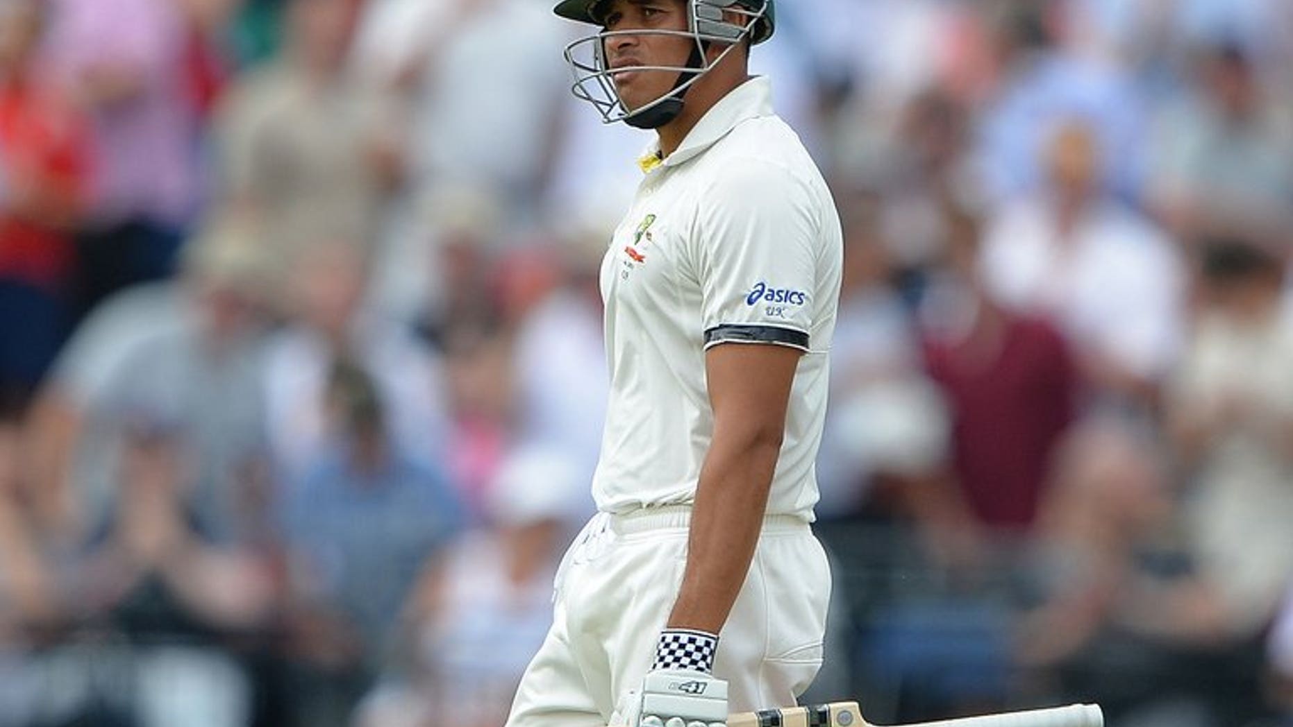 Australia's Usman Khawaja walks off after being given out during play on the first day of the third Ashes Test between England and Australia at Old Trafford in Manchester, England, on August 1, 2013. Khawaja, who faces a battle to keep his place in the Australia team for this week's final Ashes Test, has had his central playing contract upgraded, Cricket Australia said Monday.