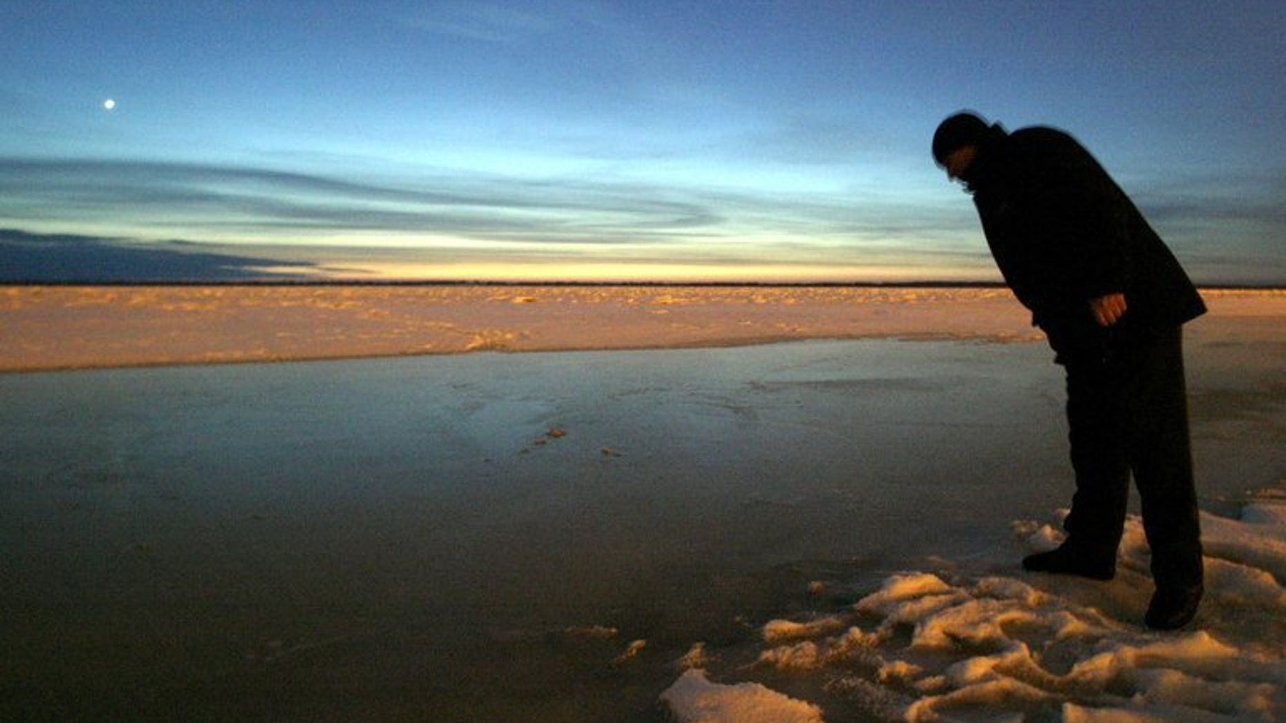 File picture shows a local resident looking into the Amur river in Khabarovsk, eastern Russia, December 24, 2005. Floods on the Amur River in Russia's Far East broke historic records Monday as authorities evacuated over 19,000 people from affected areas and warned of a further rise in water levels.