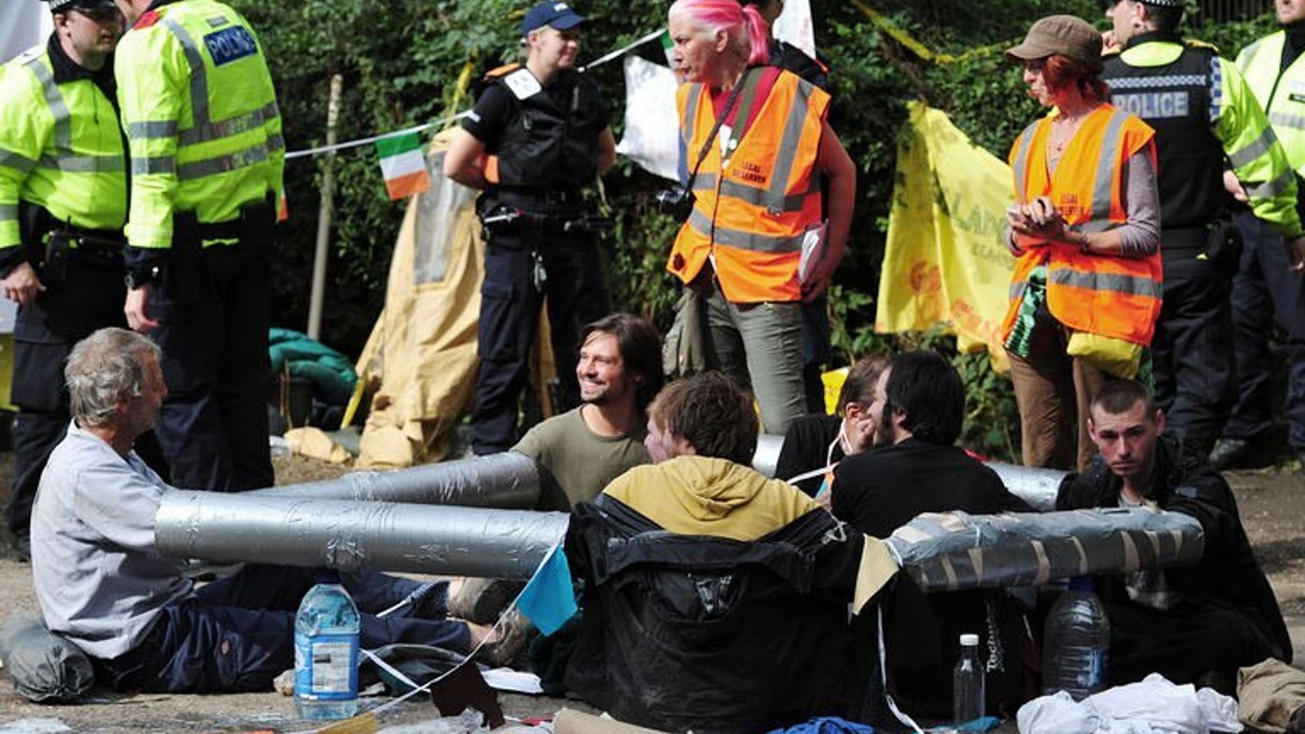 Anti-fracking and climate protesters with their arms bound together demonstrate near the test drill site operated by British energy firm Cuadrilla Resources in Balcombe, southern England, on August 19, 2013.