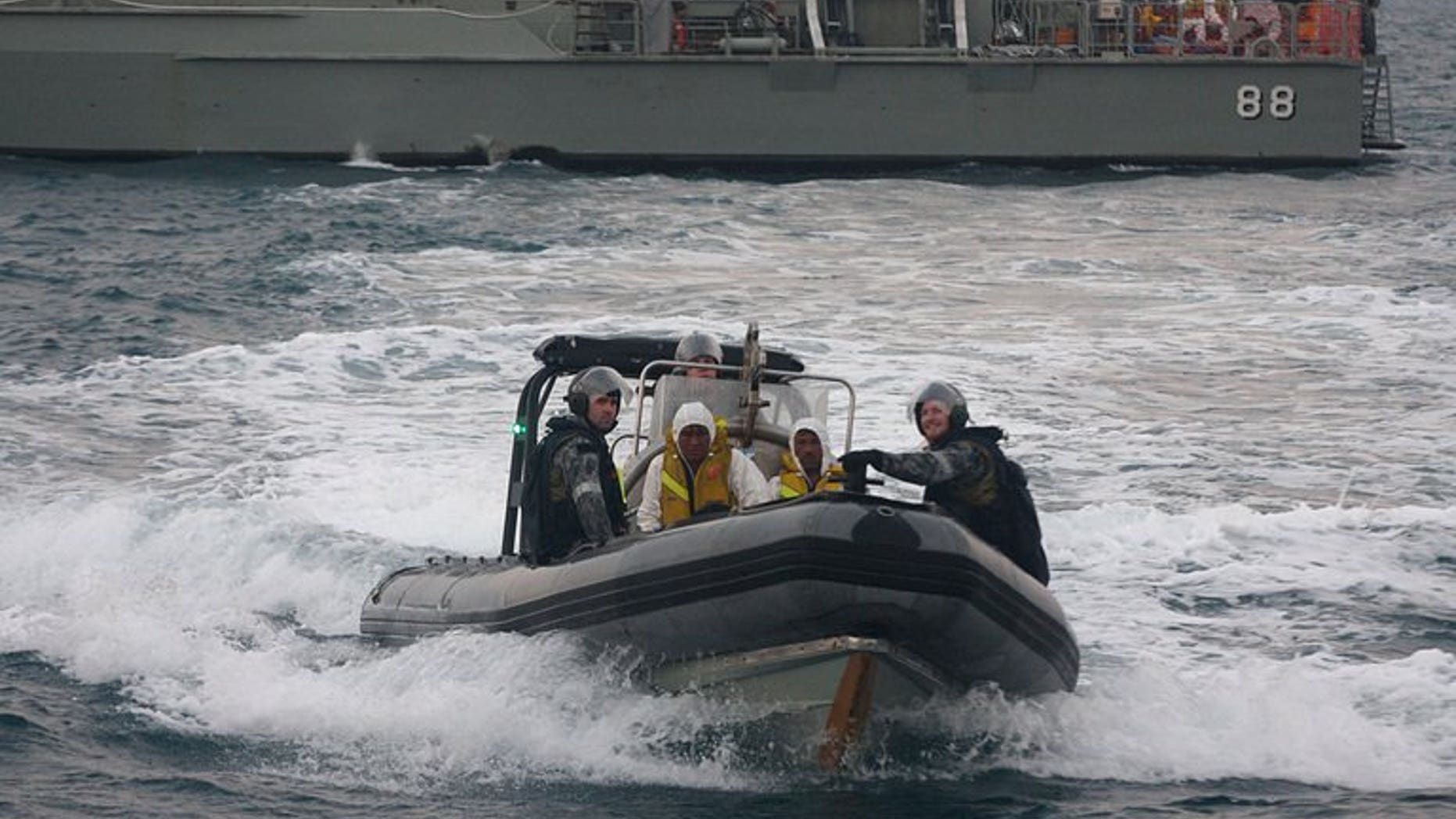 Australian navy personnel transfer asylum-seekers to a rescue boat near West Java on August 31, 2012. A rescue operation was underway Tuesday after an asylum-seeker boat started to sink off Christmas Island.