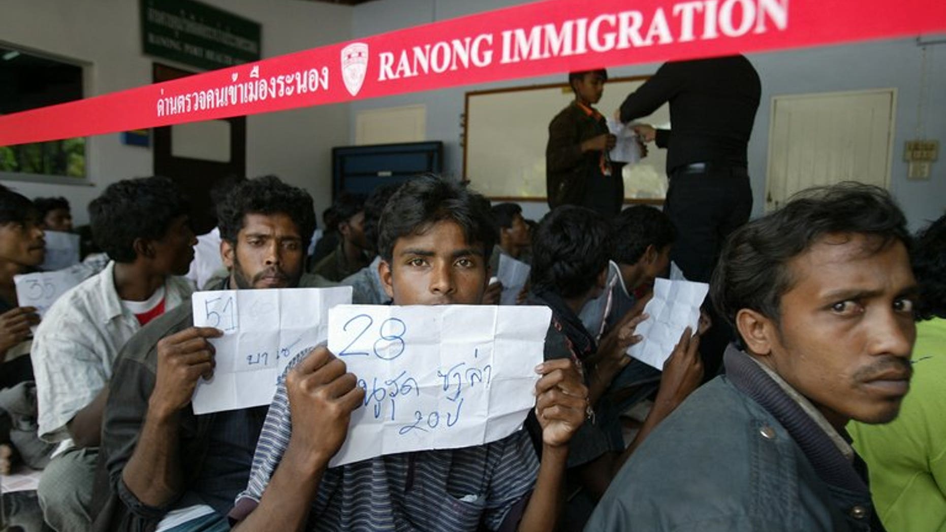 Rohingya migrants sit outside a police station before being transported to Thai police immigration on January 31, 2009. On Tuesday dozens escaped from a Thai immigration centre, police said.