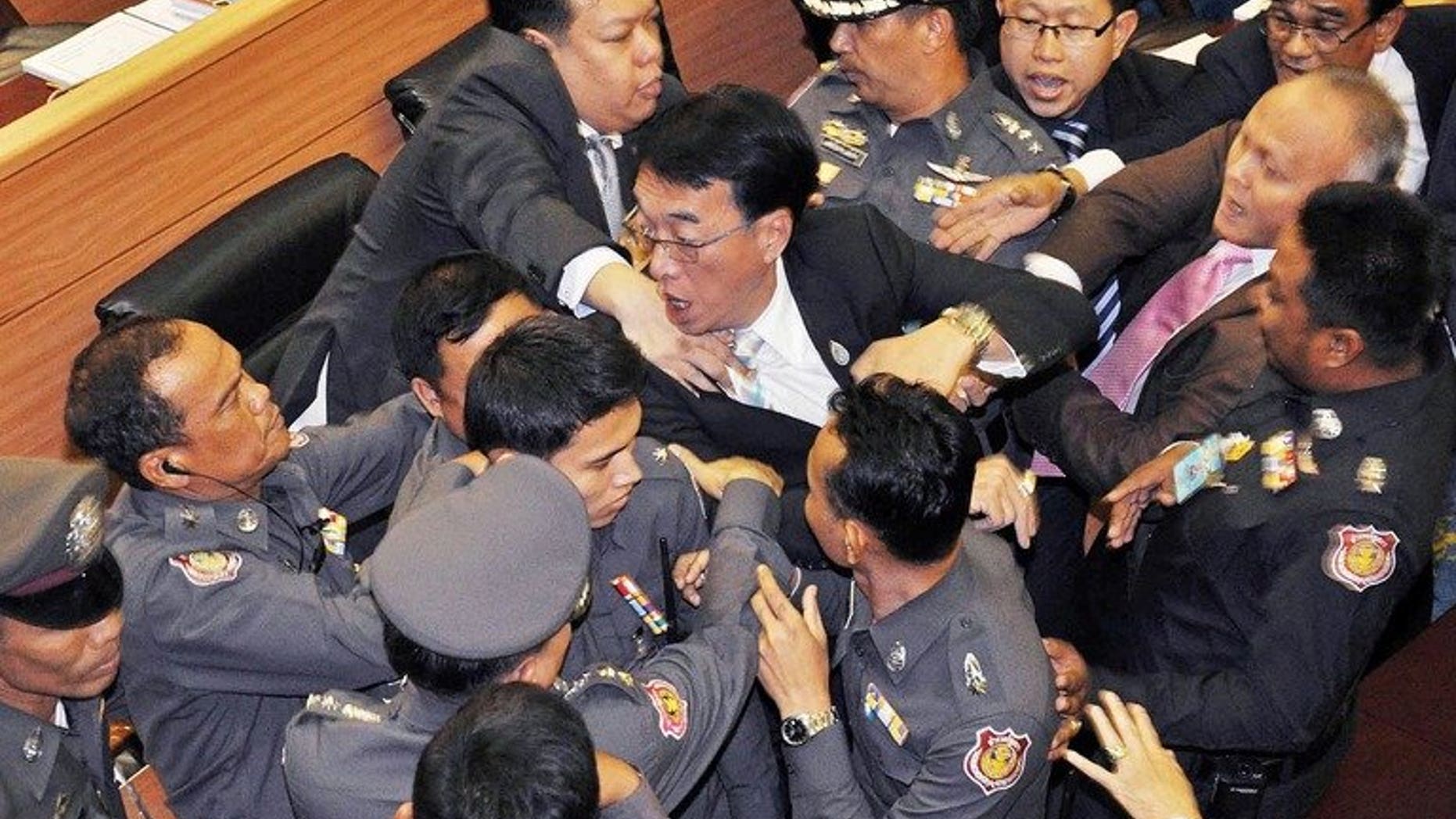 Members of the opposition Democrat party (C) are surrounded by parliament police officers during a brawl in parliament in Bangkok on August 20, 2013. Thailand's parliament briefly descended into chaos on Tuesday as opposition lawmakers brawled with police during a debate on controversial proposals to amend the constitution.