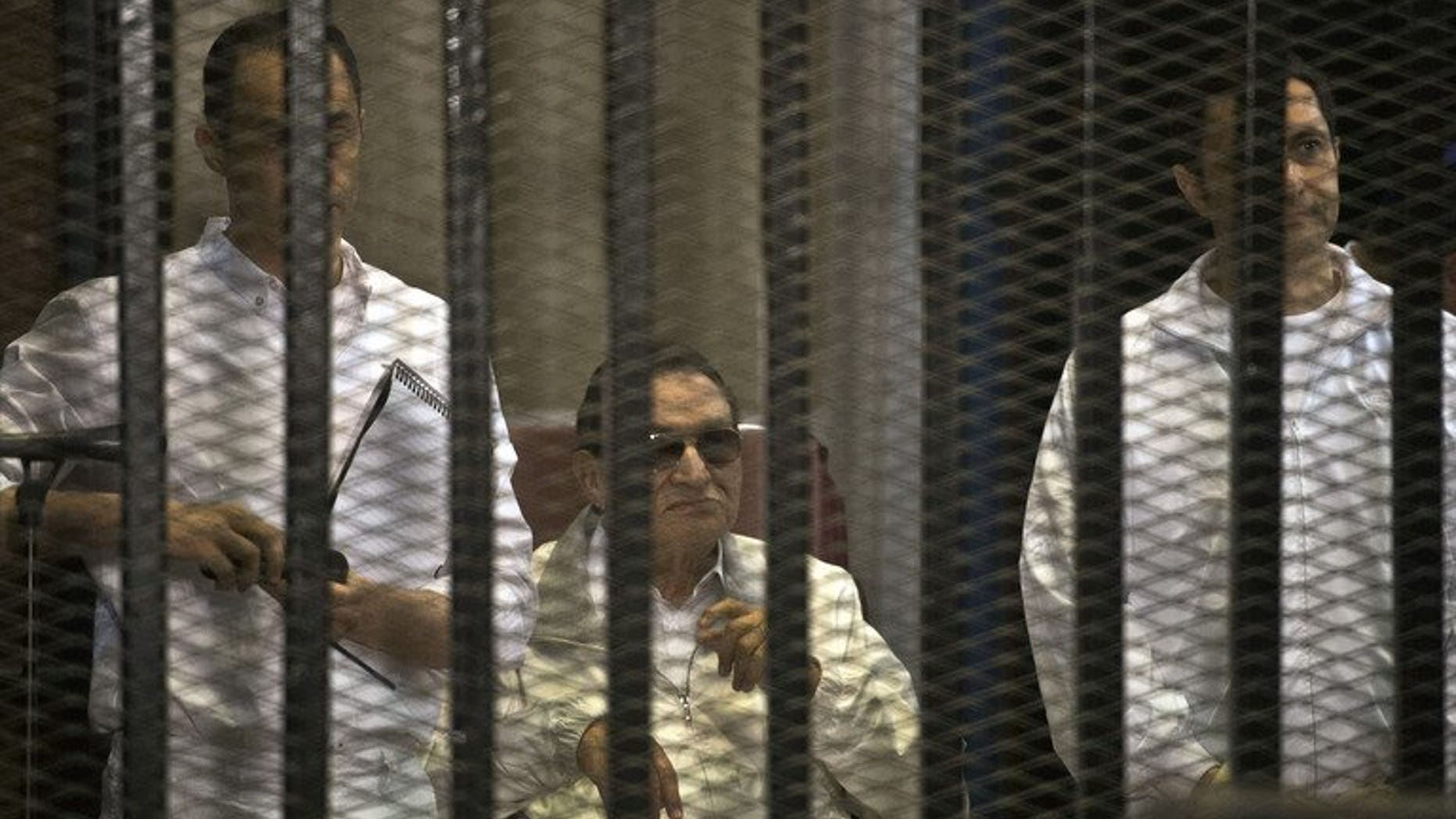Ousted Egyptian president Hosni Mubarak (C) and his two sons Alaa (R) and Gamal during their retrial at the Police Academy in Cairo on June 8, 2013. Mubarak will face a new court hearing on Wednesday during which his lawyer will seek his release from prison, judicial sources said
