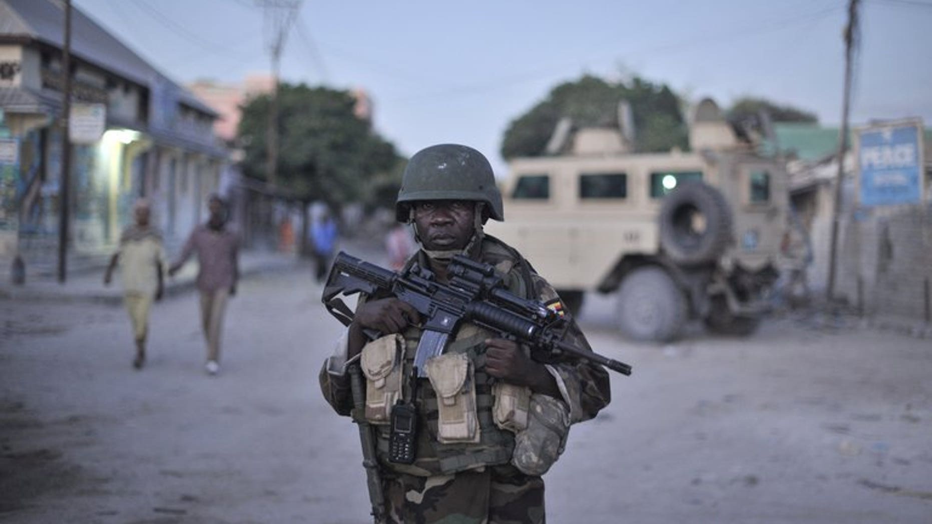 An AMISOM soldier monitors a street in Mogadishu. Gunmen killed two Somalis and wounded a Swedish woman in central Mogadishu on Wednesday when they opened fire on their car in the latest attack in the troubled city, police said.