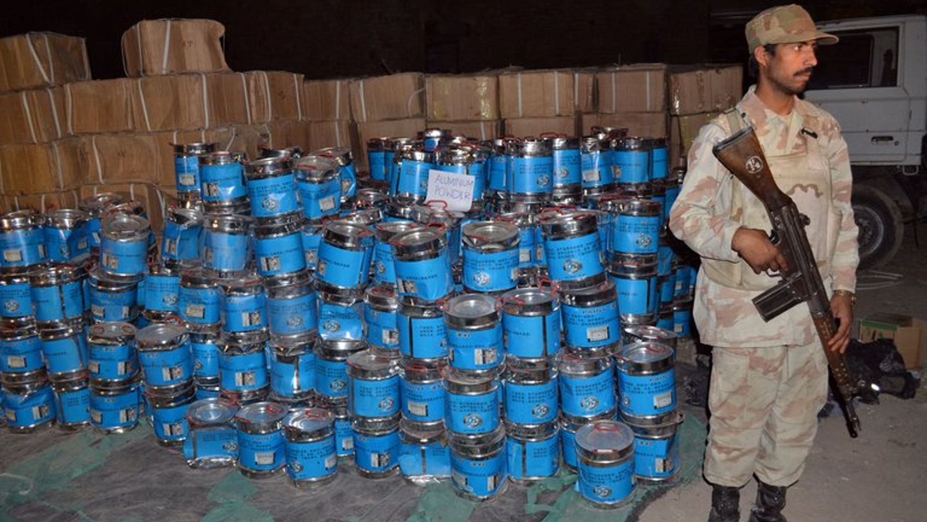 A Pakistani paramilitary soldier stands beside the seized bomb making material in Quetta on August 20, 2013. Pakistani authorities said Wednesday that a car bomb factory where troops confiscated more than 100 tones of chemicals had been used in recent attacks on troops and minority Shiite Muslims.