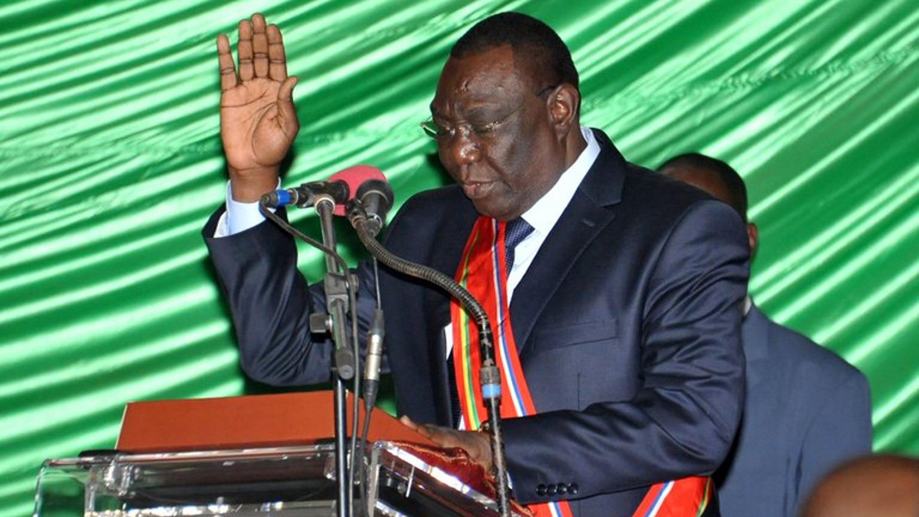 Former rebel leader Michel Djotodia takes the oath during a swearing-in ceremony on August 18, 2013 in Bangui. At least 11 people were killed and 35 injured in clashes that erupted when the new Central African Republic government tried to disarm supporters of ousted leader Francois Bozize, hospital sources said Wednesday.