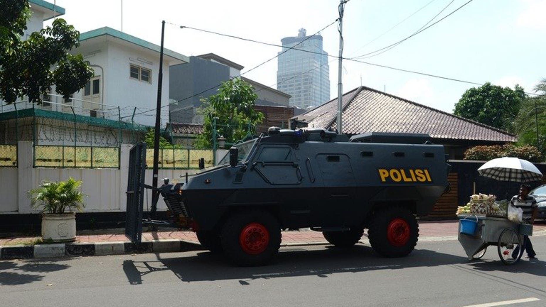 An Indonesian police armored vehicle (C) stands posted outside the Myanmar embassy compound (back L) in Jakarta before the arrival of anti-Myanmar demonstrators on May 3, 2013. Indonesian police have arrested four men suspected of involvement in a failed plot to bomb the Myanmar embassy in Jakarta, an official said Wednesday.