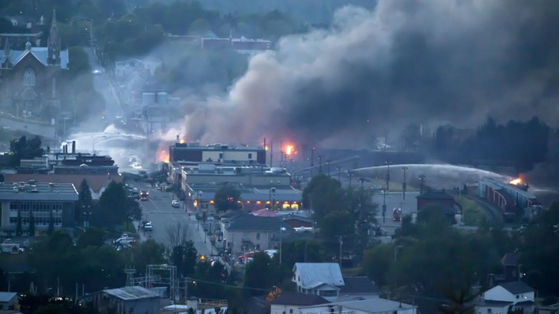 Firefighters douse blazes after a freight train loaded with oil derailed in Lac-Megantic in Canada's Quebec province on July 6, 2013. Canada's Senate called for a full safety review of pipelines, railroads and other means of transporting crude oil, in a report Thursday that also urges better responses to spills.