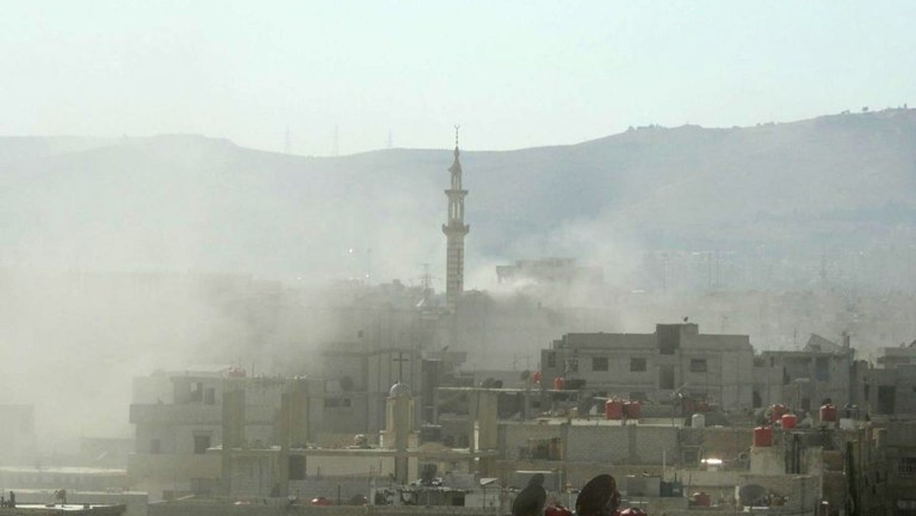 A handout image released by the Syrian opposition's Shaam News Network shows smoke above buildings following what Syrian rebels claim to be a toxic gas attack by pro-government forces in eastern Ghouta, on the outskirts of Damascus on August 21, 2013.