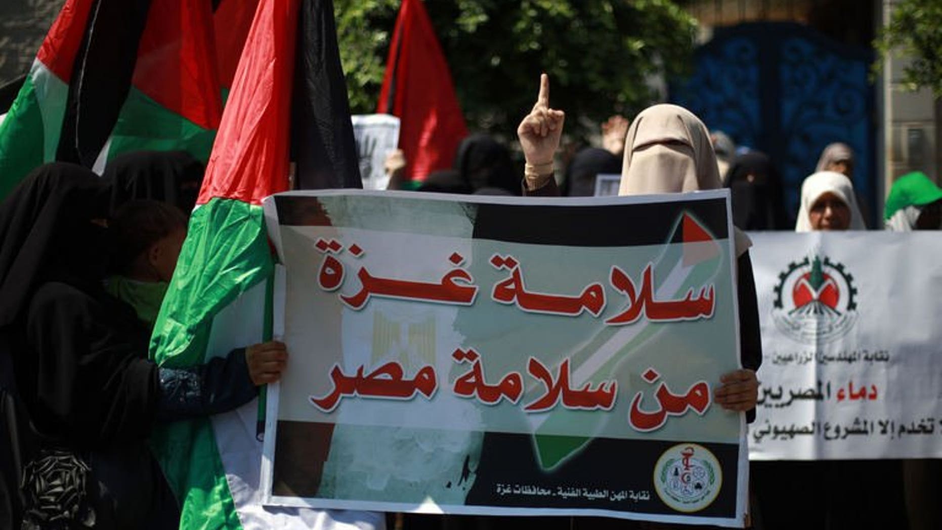 A female Palestinian protester carries a placard and gestures during a rally in support of ousted Egyptian president Mohamed Morsi, in Gaza City on August 19, 2013. Palestinian security services have arrested an Islamist sympathiser in the West Bank for selling perfume named in honour of Egypt's ousted president Mohamed Morsi, family members said on Thursday.
