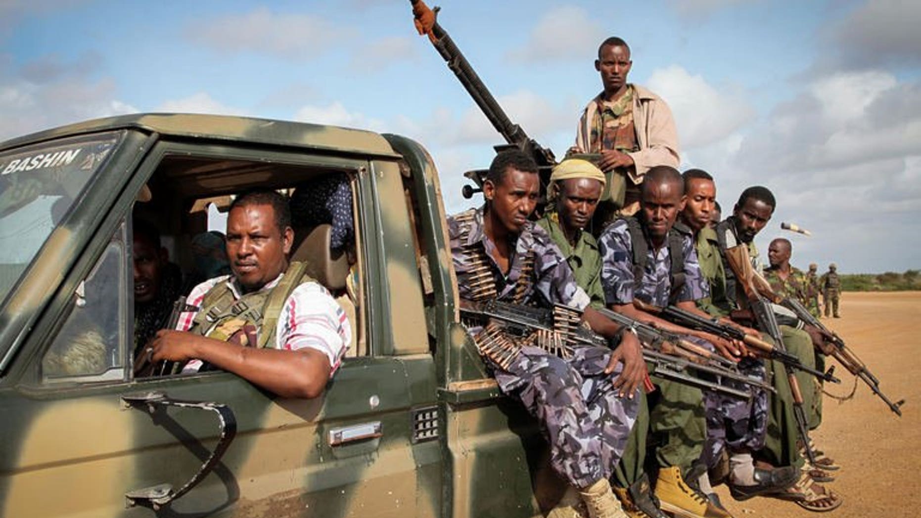 Fighters belonging to the pro-government Ras Kimboni Brigade ride on the back of a machine mounted truck at the Kismayo Airport in southern Somalia on August 22, 2013. African troops in Somalia said they thwarted an attack Thursday by Islamist Shebab fighters on their base in the southern port city of Kismayo.