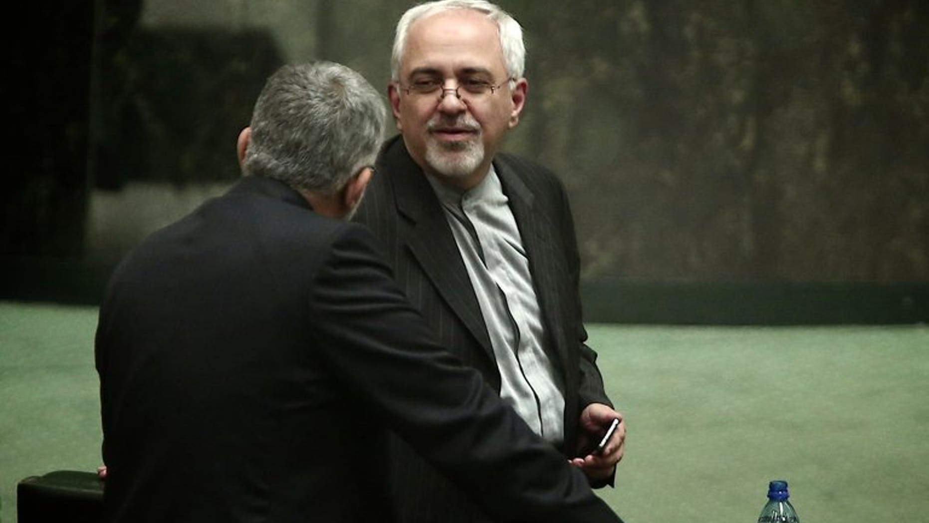 Mohammad Javad Zarif speaks with an MP in parliament in Tehran on August 15, 2013. The possession of a nuclear bomb would threaten Iran's security, the country's foreign minister, Mohammad Javad Zarif, said in comments reported on Friday.