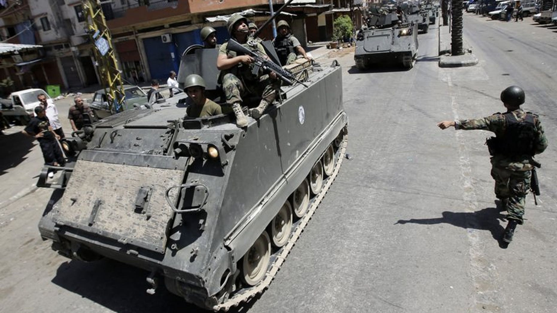 Lebanese army soldiers patrol Syria street in Tripoli's Sunni neighbourhood of Bab al-Tabbaneha on June 7, 2013. Two explosions went off within minutes of each other in the northern Lebanese city of Tripoli on Friday, an AFP photographer and the National News Agency reported.