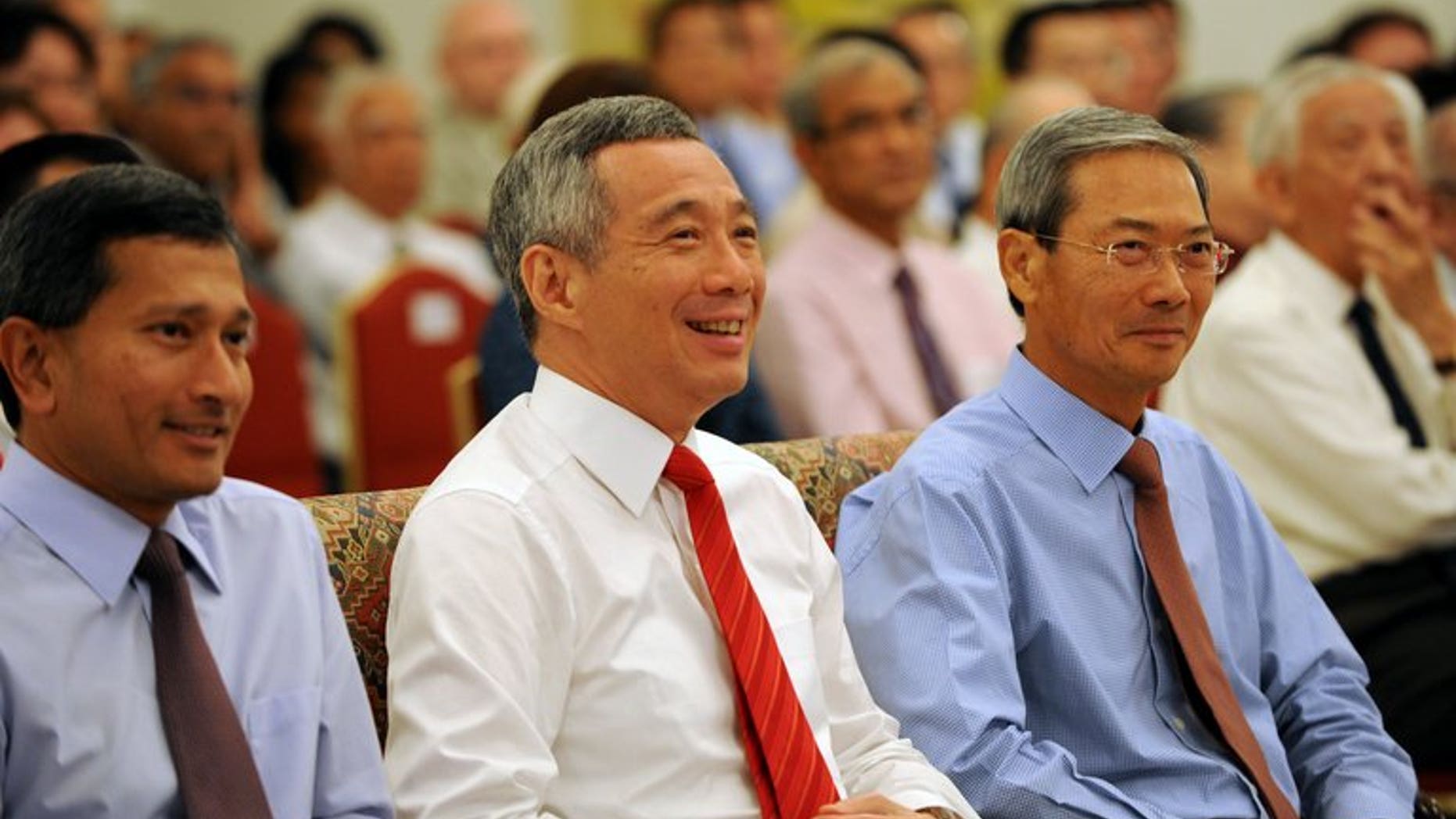 Singapore Prime Minister Lee Hsien Loong (centre) attends a book launch at the Istana Presidential Palace in Singapore on August 6, 2013. Singapore Prime Minister Lee Hsien Loong's efforts to connect with younger voters may finally pay off after a photo of him doing his first fist bump went viral on Facebook.