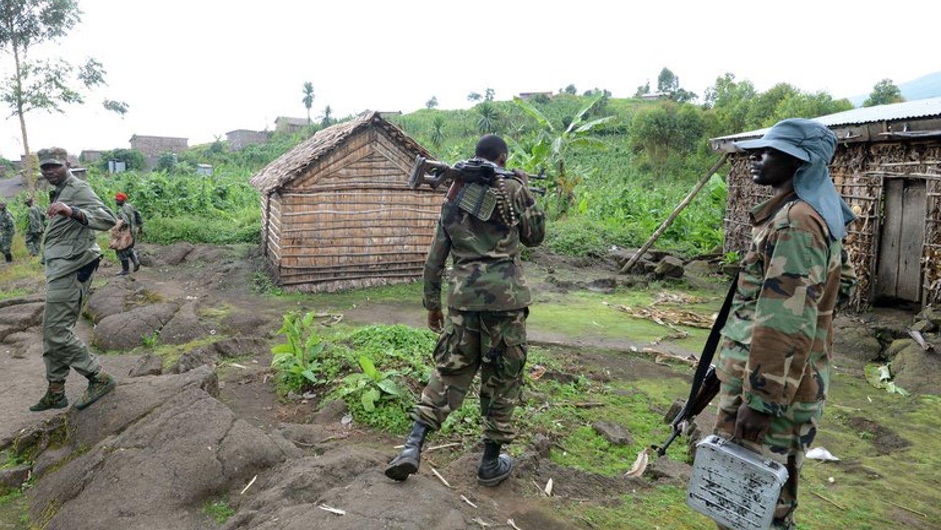 Fighters of the M23 rebel group take positions in Mutaho on June 3, 2013 about 15 kms from the eastern Democratic Republic of Congo city of Goma. Shelling killed two people in Goma Saturday, a day after a newly-formed UN force for the first time took on M23 rebels threatening the eastern Congolese city, witnesses said.