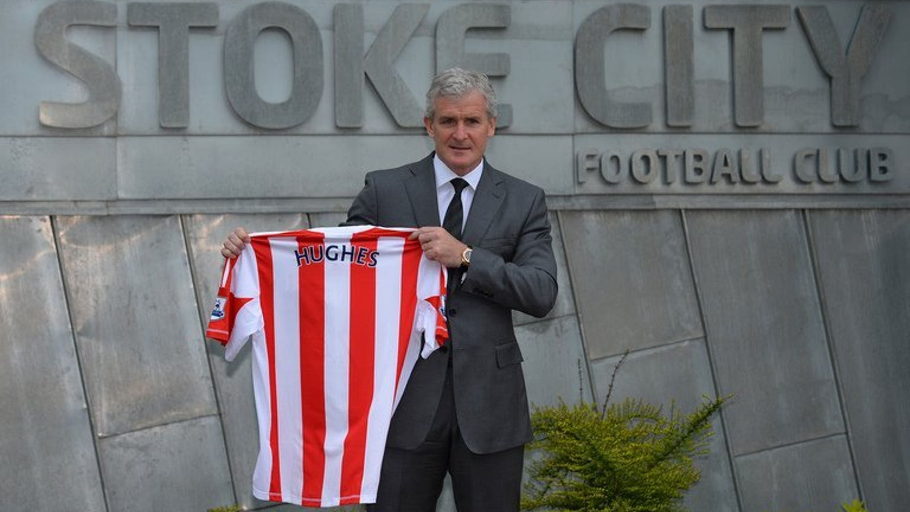 Mark Hughes holds up a Stoke City football shirt at the Stoke City training ground in Stoke-on-Trent, on May 30, 2013. Stoke City stormed back from behind to beat Premier League new boys Crystal Palace 2-1 on Saturday and earn manager Hughes victory in his first home game.