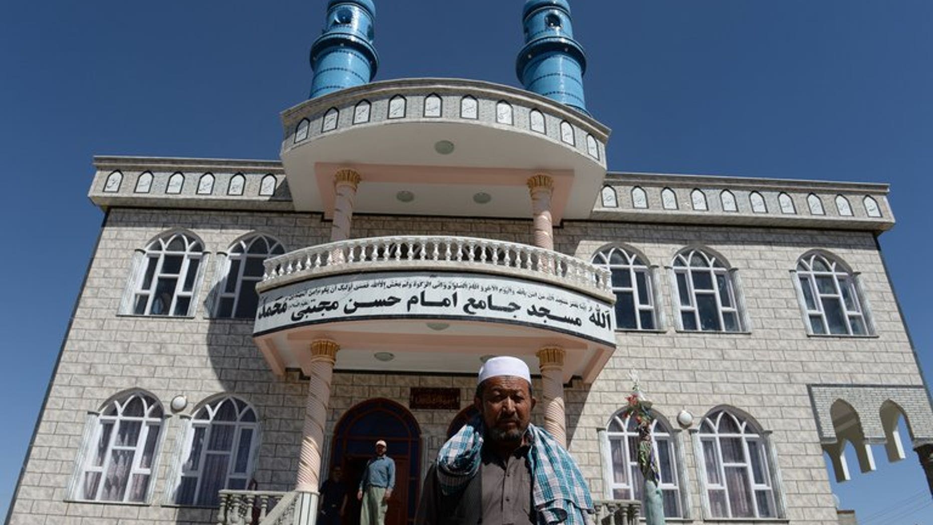 Local men stand in front of a Shiite mosque where intelligence forces killed two Pakistani terrorists in police uniforms, in Kabul, on September 5, 2013. Afghan intelligence agency said on Thursday that its spies shot dead two Pakistanis who opened fire on the worshippers before dawn at the mosque.