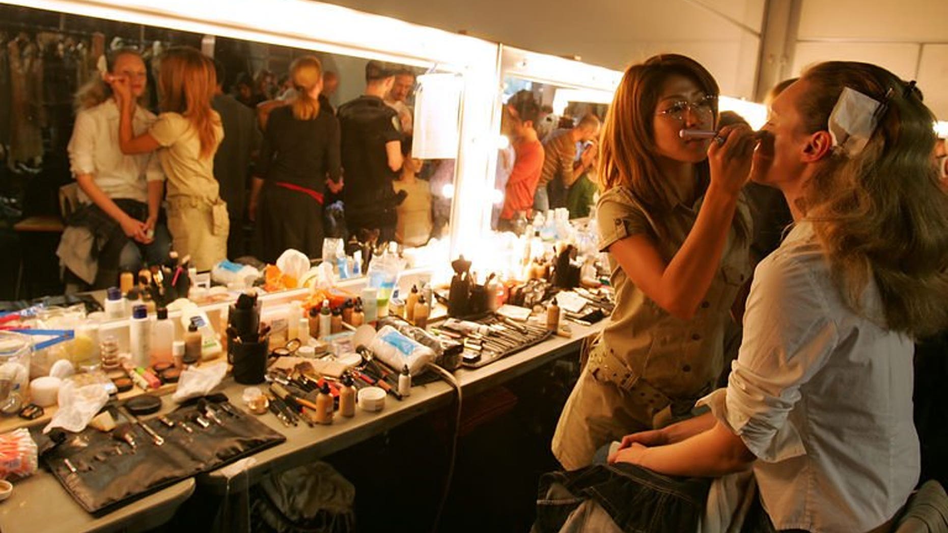 Models have final touches put to their hair and make-up in London, on September 19, 2005. Their skin is flawless, their make-up perfect and their hair sleek, but to teenage girls hoping to emulate fashion models, British Vogue has a message -- it's not real.
