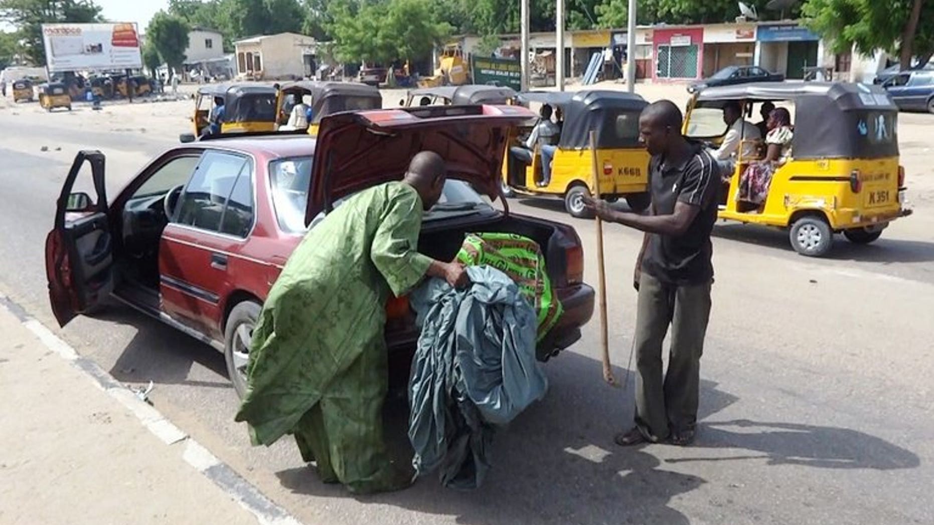A vigilante peers into the trunk of a car looking for weapons on July 19, 2013 in Maiduguri, where Boko Haram has carried out most of its deadly attacks.