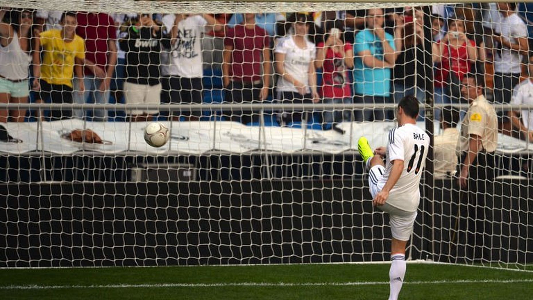 New Welsh striker of Real Madrid Gareth Bale scores a goal during his presentation at the Santiago Bernabeu stadium in Madrid on September 2, 2013.