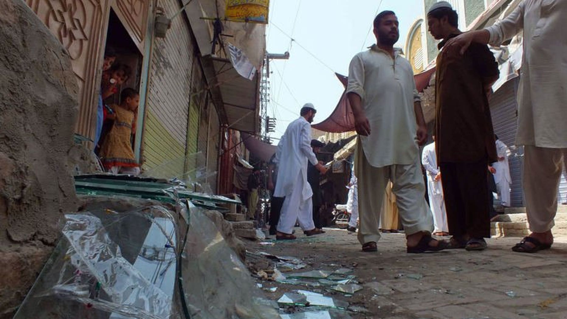 Local residents gather near the site of a bomb explosion in the northwestern town of Bannu on September 5, 2013. Gunmen attacked a mini-bus and two other vehicles near Pakistan's northwestern city of Peshawar late on Friday, killing nine people, police said.