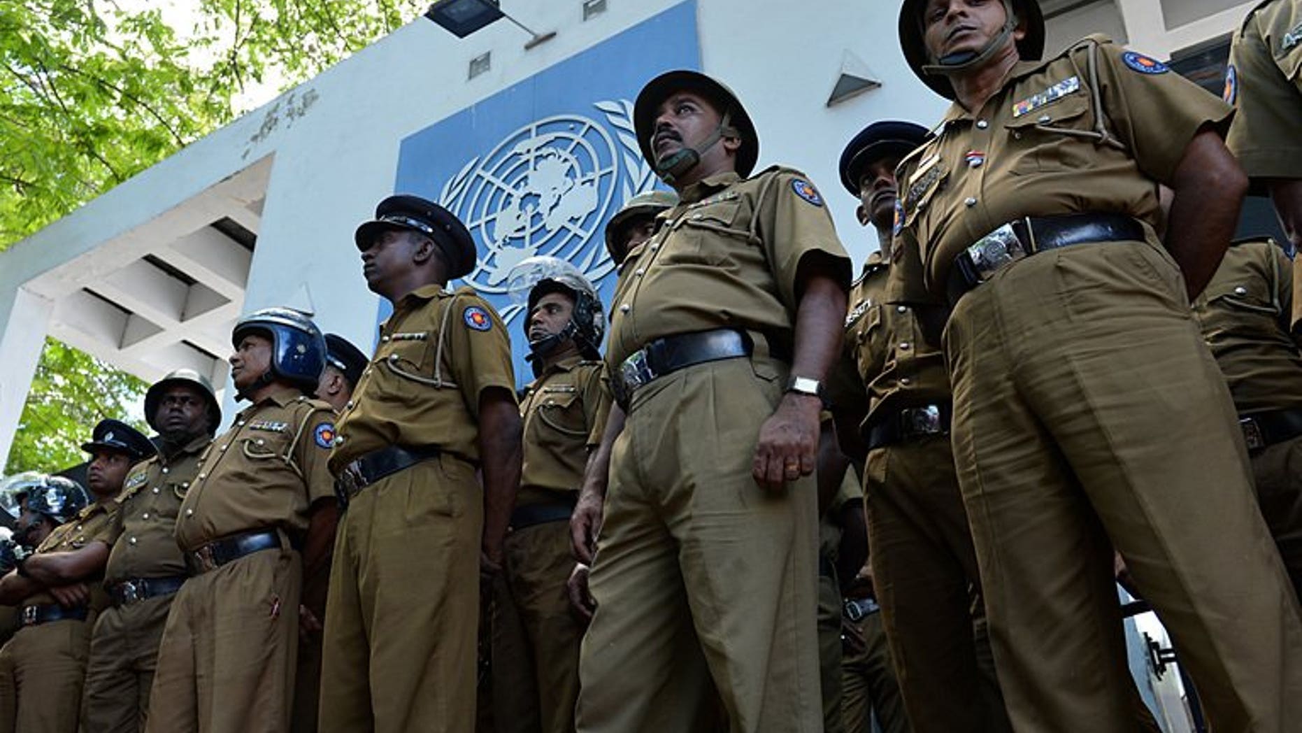 Sri Lankan police stand guard outside the UN office in Colombo on August 31, 2013. Sri Lankan police have arrested a navy officer suspected of involvement in smuggling people in fishing boats to Australia, officials said Saturday.
