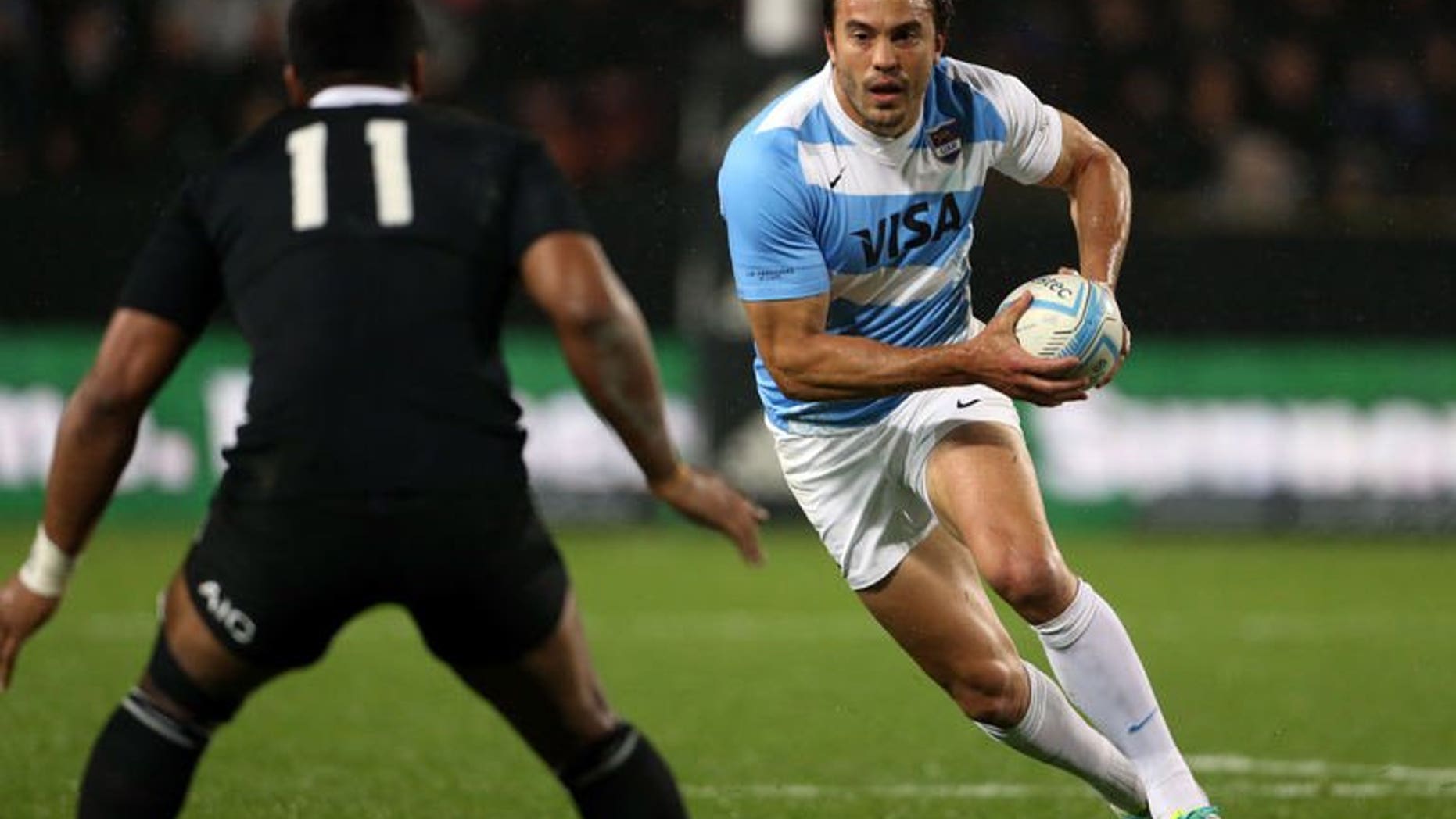 Juan Martin Hernandez of Argentina runs the ball back towards New Zealand's Julian Savea during their Rugby Championship match in Hamilton on September 7, 2013.