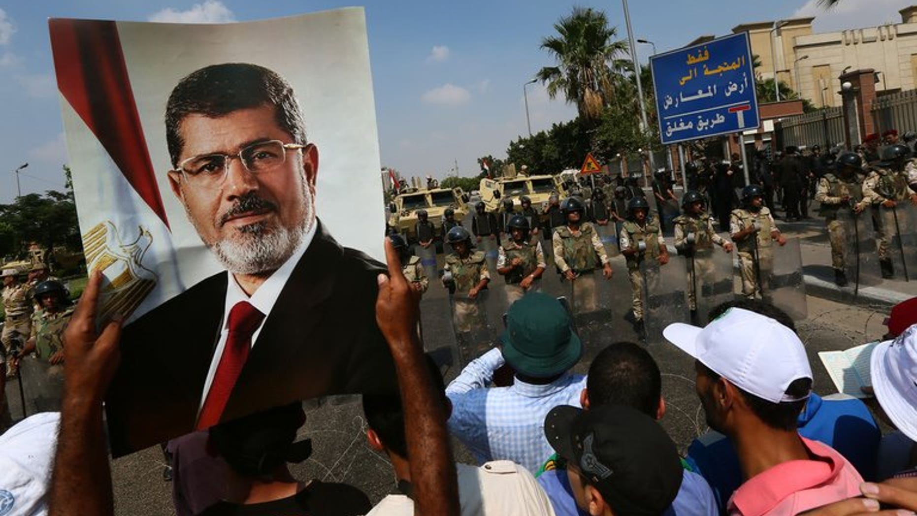 A supporter of ousted Egyptian president Mohamed Morsi holds a picture of the toppled leader in Cairo, on July 19, 2013. An Egyptian prosecutor has levelled new accusations against Mohamed Morsi, already facing trial on other charges, alleging the Islamist had insulted the country's judiciary when he was president, media reported.