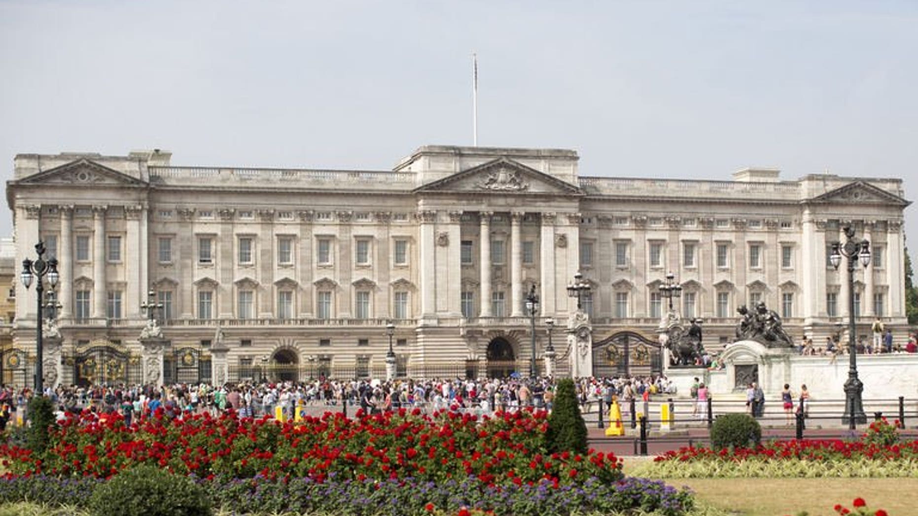 Tourists gather outside Buckingham Palace in central London on July 22, 2013. British police said they had arrested a man who scaled a fence to get into the palace, the official London residence of Queen Elizabeth II.