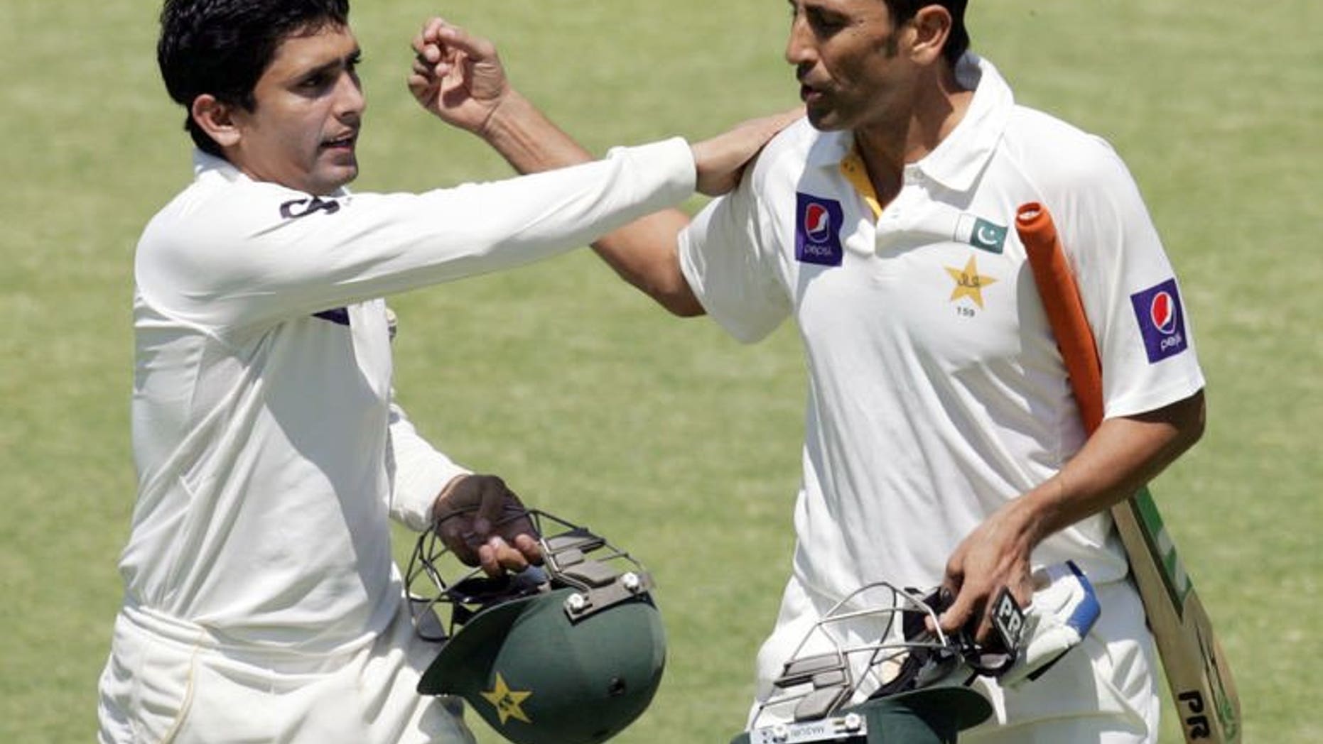 Pakistan batsman Younis Khan (right) is congratulated by Adnan Akmal (left) during the fourth day of the first cricket Test against Zimbabwe in Harare on September 6, 2013. Pakistan beat Zimbabwe by 221 runs on the fifth day.
