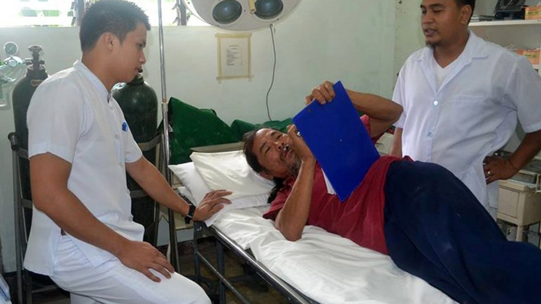 In this handout photo taken on September 4, 2013, Taiwanese fisherman Tsai Po, 54 (centre) is attended to by medical personnel at the Batanes General Hospital, on September 4, 2013. Philippine police say there is strong evidence to charge Tsai -- detained after he strayed into the archipelago's waters -- in an incident that is threatening reviving relations between the neighbours.