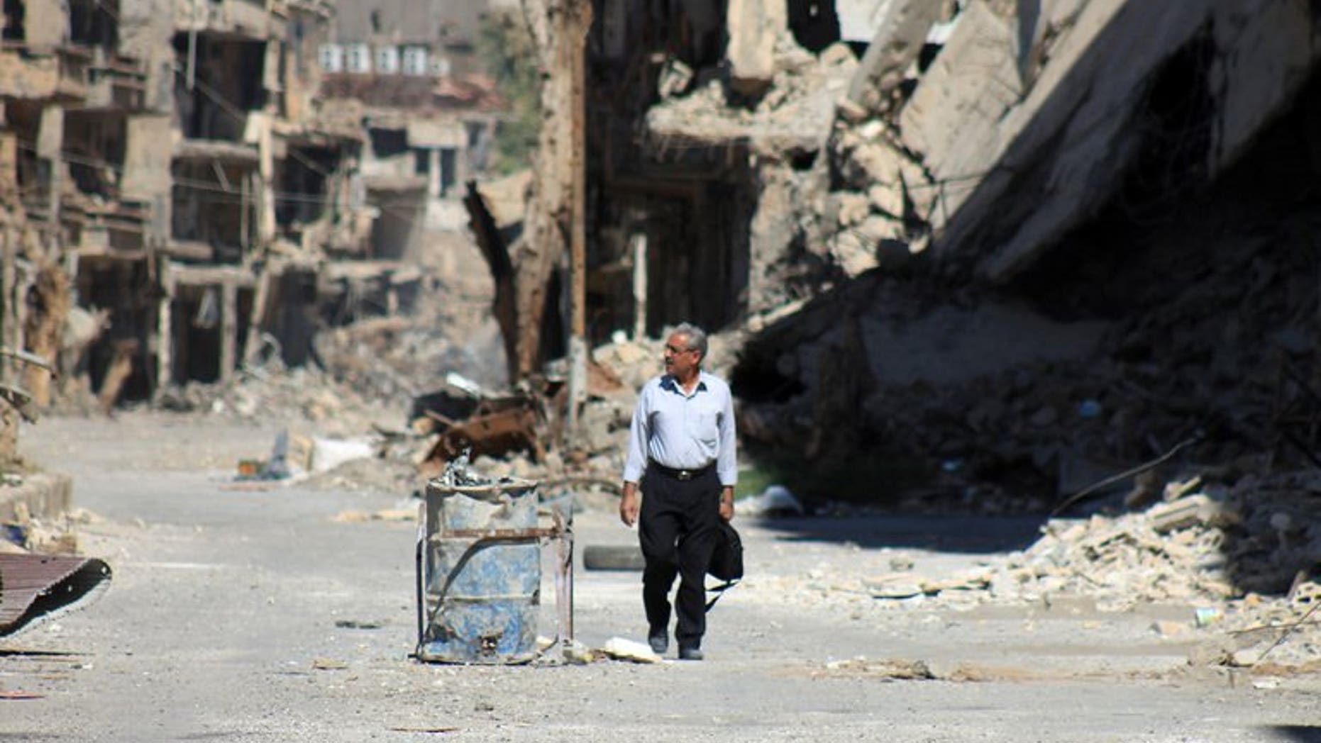 A Syrian man walks down a destroyed street in the centre of Deir Ezzor, the largest city in eastern Syria, on September 6, 2013. British Foreign Secretary William Hague has called for a strong response to the use of chemical weapons in Syria, saying the issue went wider than the conflict in the Middle Eastern country.