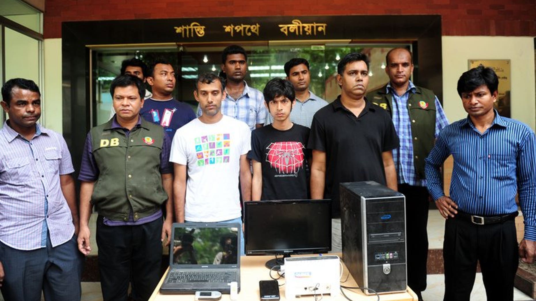 Bangladeshi police officials pose with three bloggers (C) during a press conference in Dhaka on April 2, 2013. Four Bangladeshi bloggers are facing up to seven years in jail after they were charged in court Sunday with defaming Islam and the Prophet Mohammed, a prosecutor told AFP.
