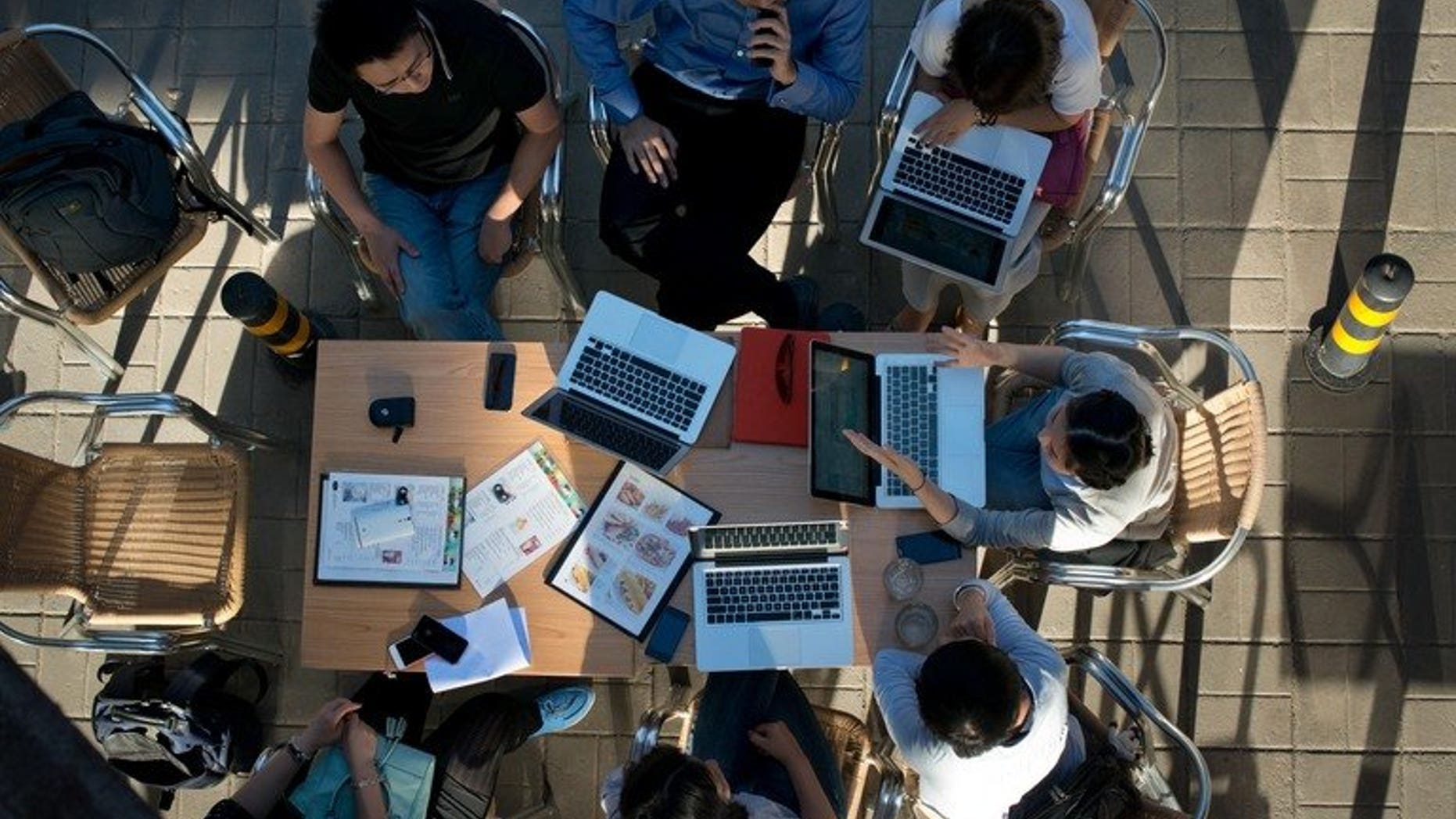 People sit around laptop computers at a cafe in Beijing on May 29, 2013. Chinese Internet users could face three years in prison for writing defamatory messages that are then re-posted 500 times under regulations announced amid a broader crackdown on "online rumours".