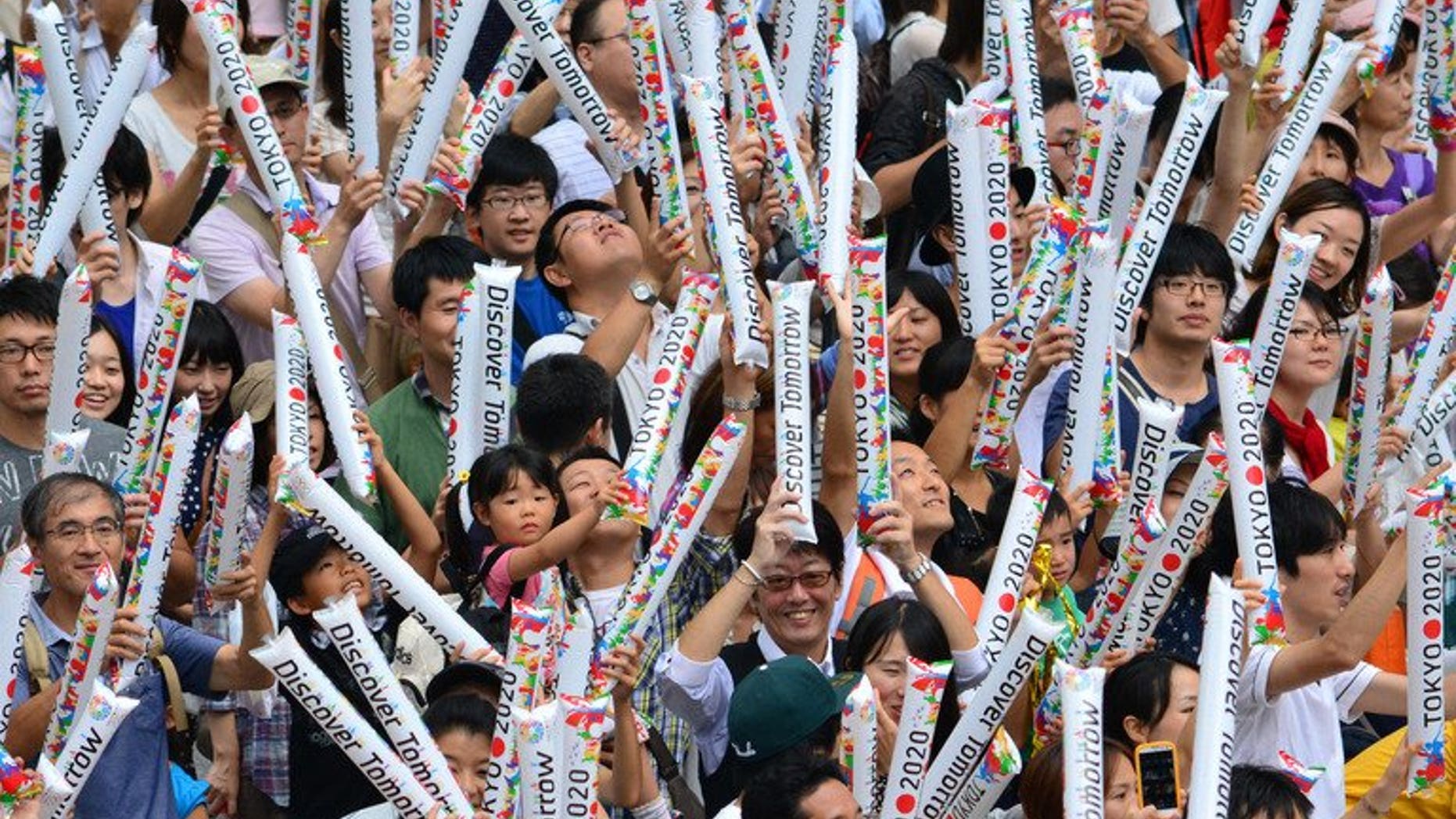 People gathering at the Tokyo metropolitan government building celebrate Tokyo's winning bid to be the host city of the 2020 Olympics on September 8, 2013. Chinese state-run media offered Tokyo heavily qualified congratulations Monday for winning the right to host the 2020 Olympics, saying the event's success would depend on Japan recognising its World War II aggression.