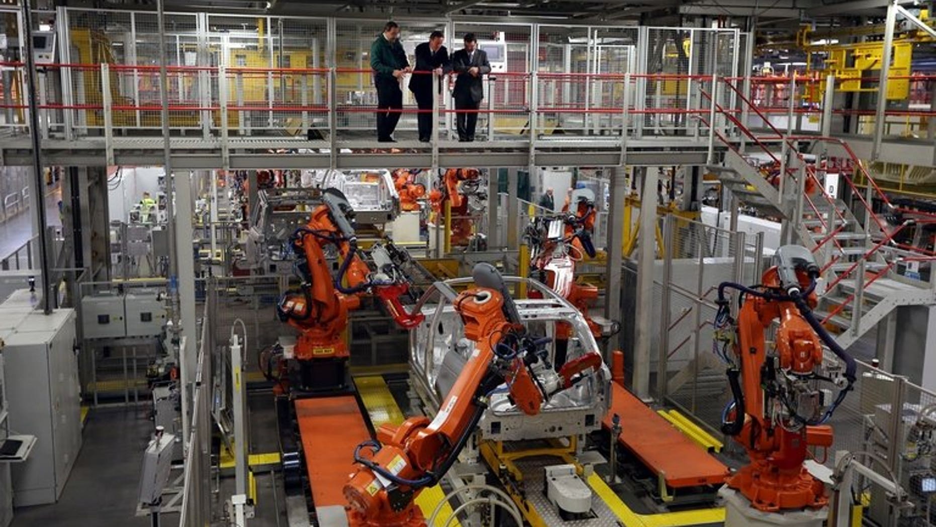Prime Minister David Cameron (C) visits the Jaguar Land Rover (JLR) plant in Solihull on December 7, 2012. Indian-owned luxury carmaker Jaguar Land Rover says it will create 1,700 jobs at the British plant in a ??1.5-billion ($2.4-billion, 1.8-billion-euro) investment.