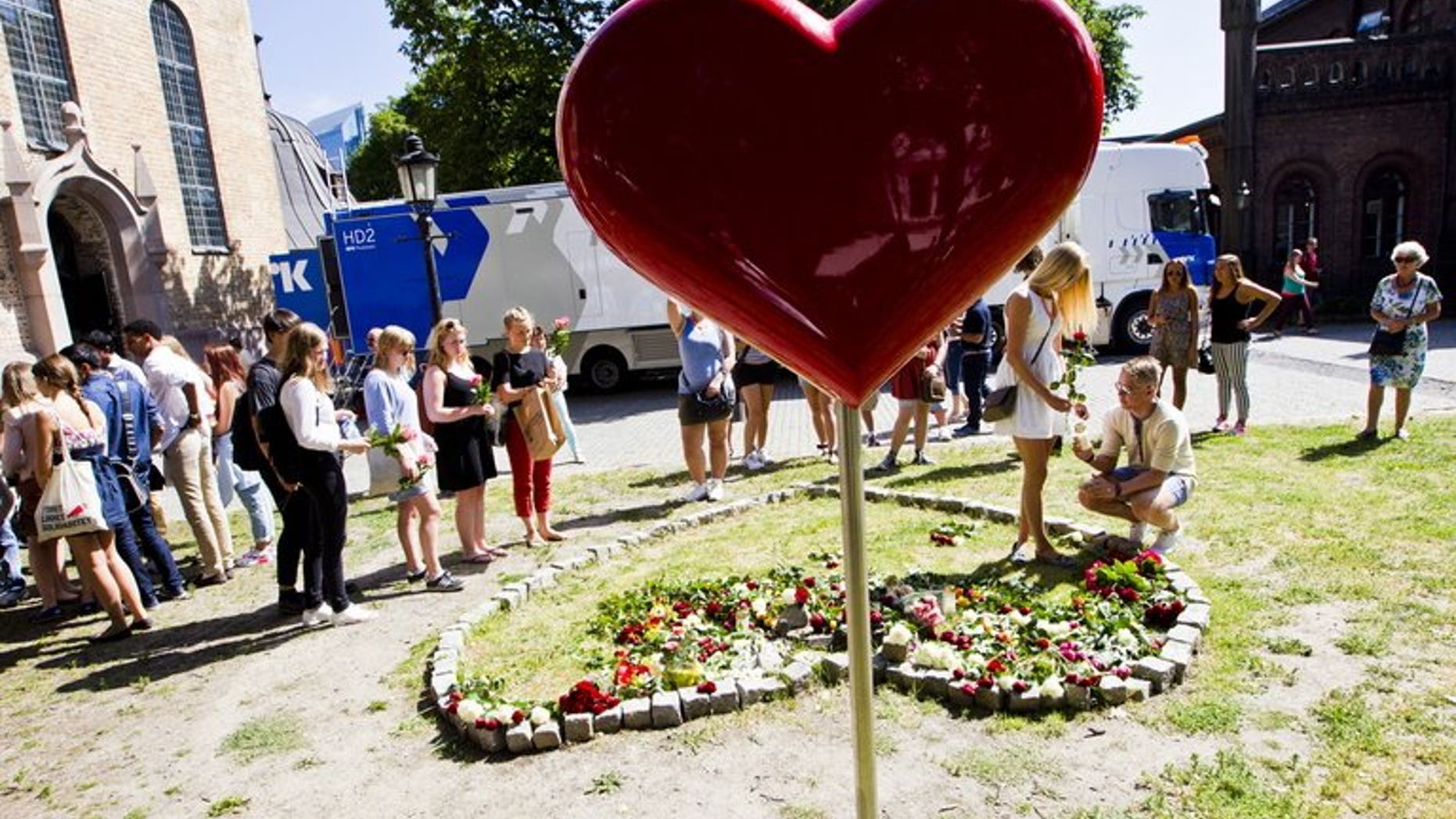 People lay flowers outside Oslo Cathedral, after a memorial service for the second anniversary of the massacre by Anders Breivik on July 22, 2013. Four young Norwegian Labour Party members who survived rightwing extremist Anders Behring Breivik's bloody rampage two years ago have been elected to parliament, the party said Tuesday.