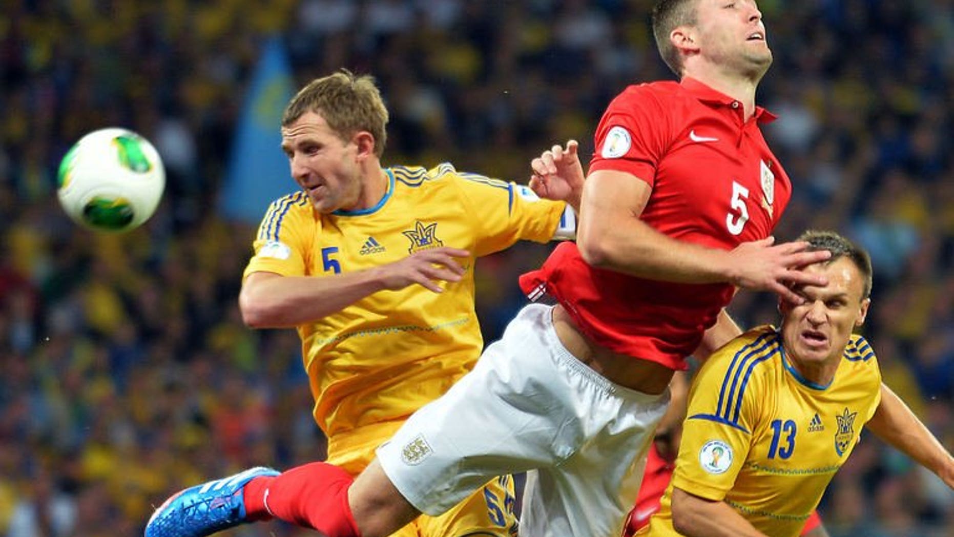 England's defender Gary Cahill (C) challenges Ukraine's defenders Olexandr Kucher (L) and Vyacheslav Shevchuk (R) during the 2014 FIFA World Cup European zone group H football match in Kiev on September 10, 2013. The match ended 0-0.