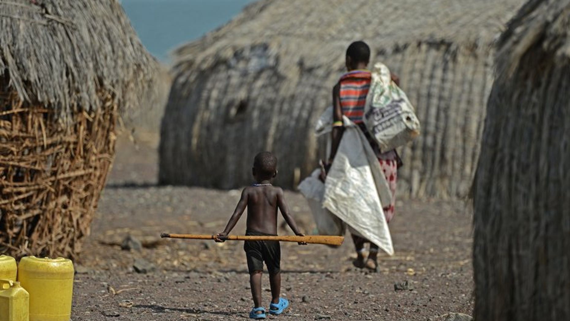 A mother and child walk in the village of Komote on the shores of Lake Turkana, northern Kenya on May 18, 2012. The Kenyan government and UNESCO announced the discovery of a potentially vast supply of underground water in the impoverished, drought-stricken extreme north of the country.