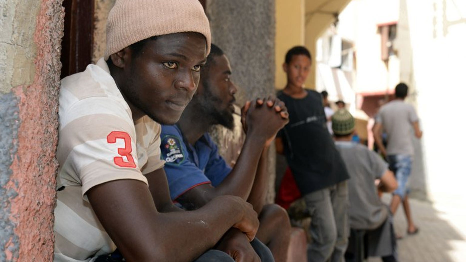Senegalese immigrants sit in front of a building in Rabat on August 23, 2013. Morocco announced a new immigration policy, pledging to review cases according to specific criteria, following sharp criticism over its treatment of sub-Saharan migrants.